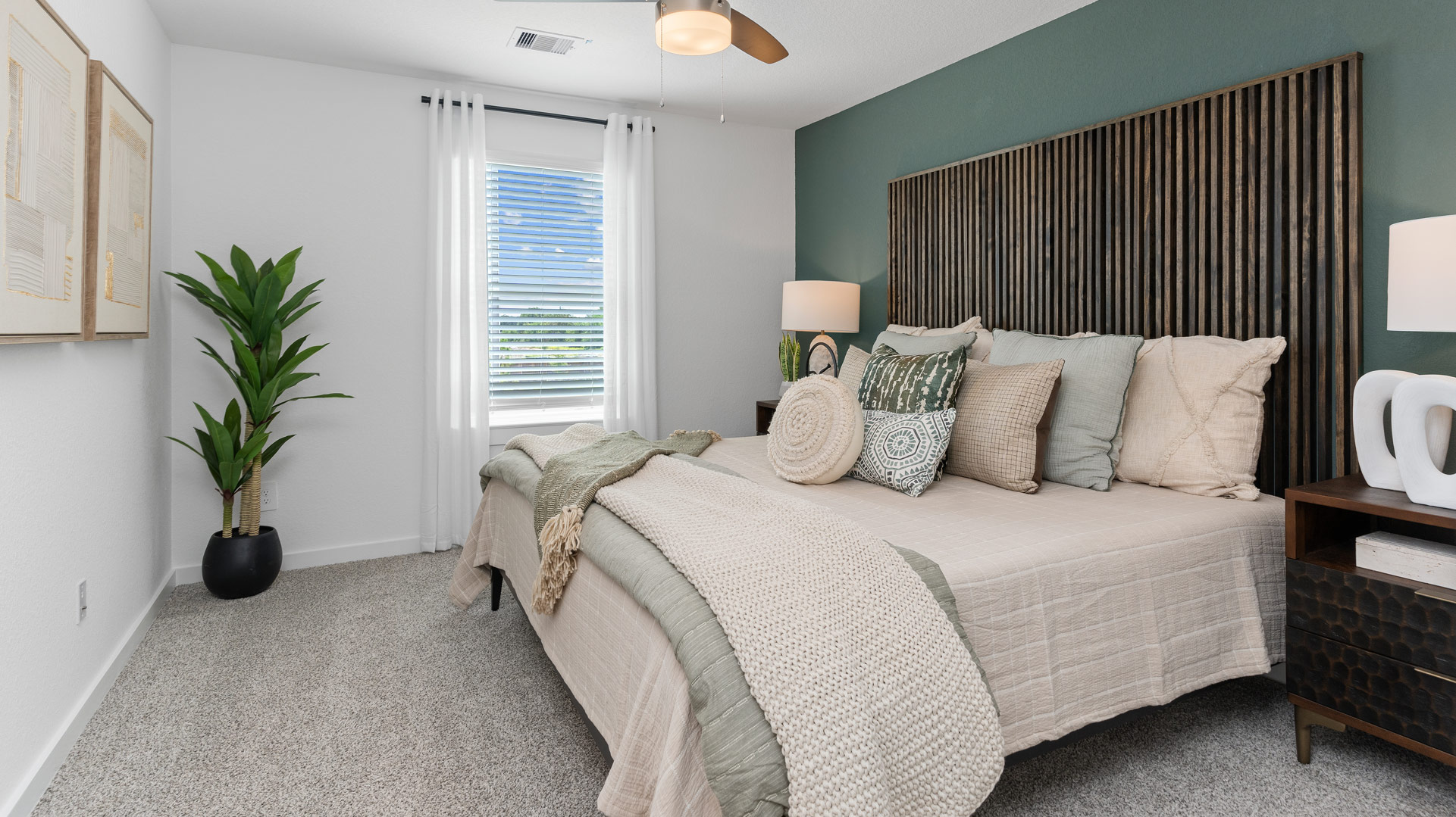 the spacious primary bedroom has natural light, carpet flooring, and ample space for a king size bed with additional bedroom furniture
