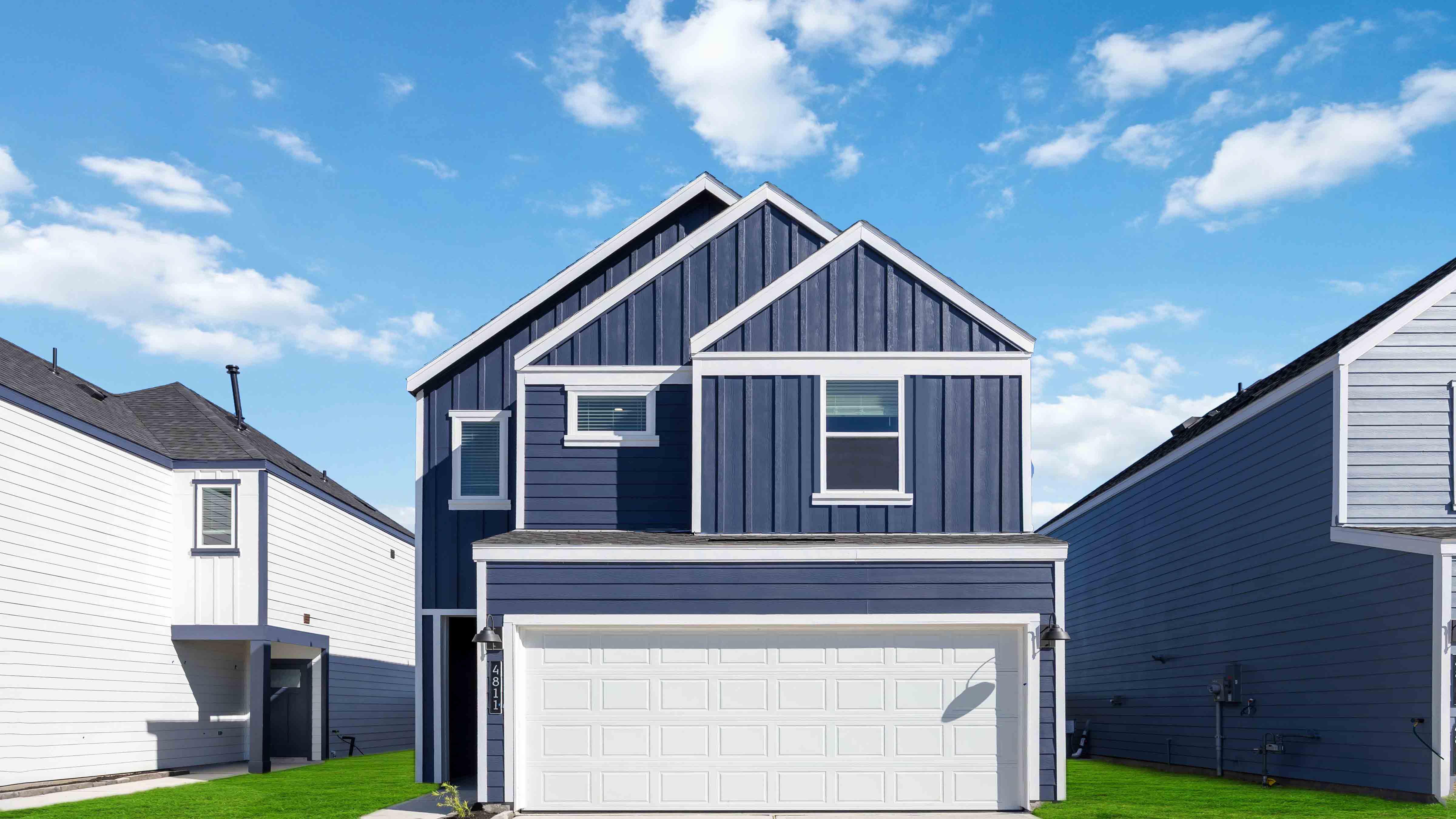 Two-story home with dark grey blue siding and a two car garage