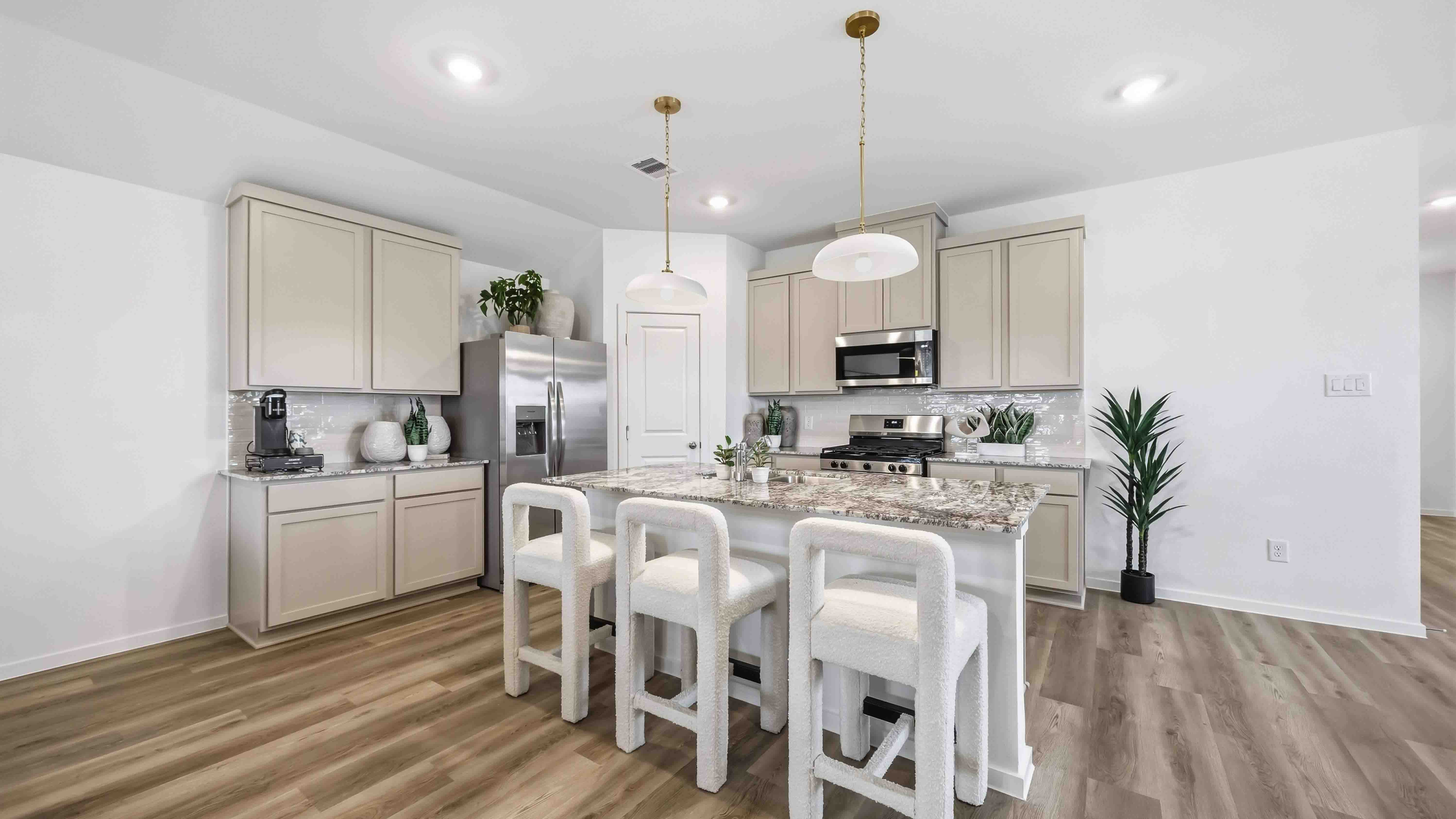 spacious kitchen with an island that has availability with three seats for additional space
