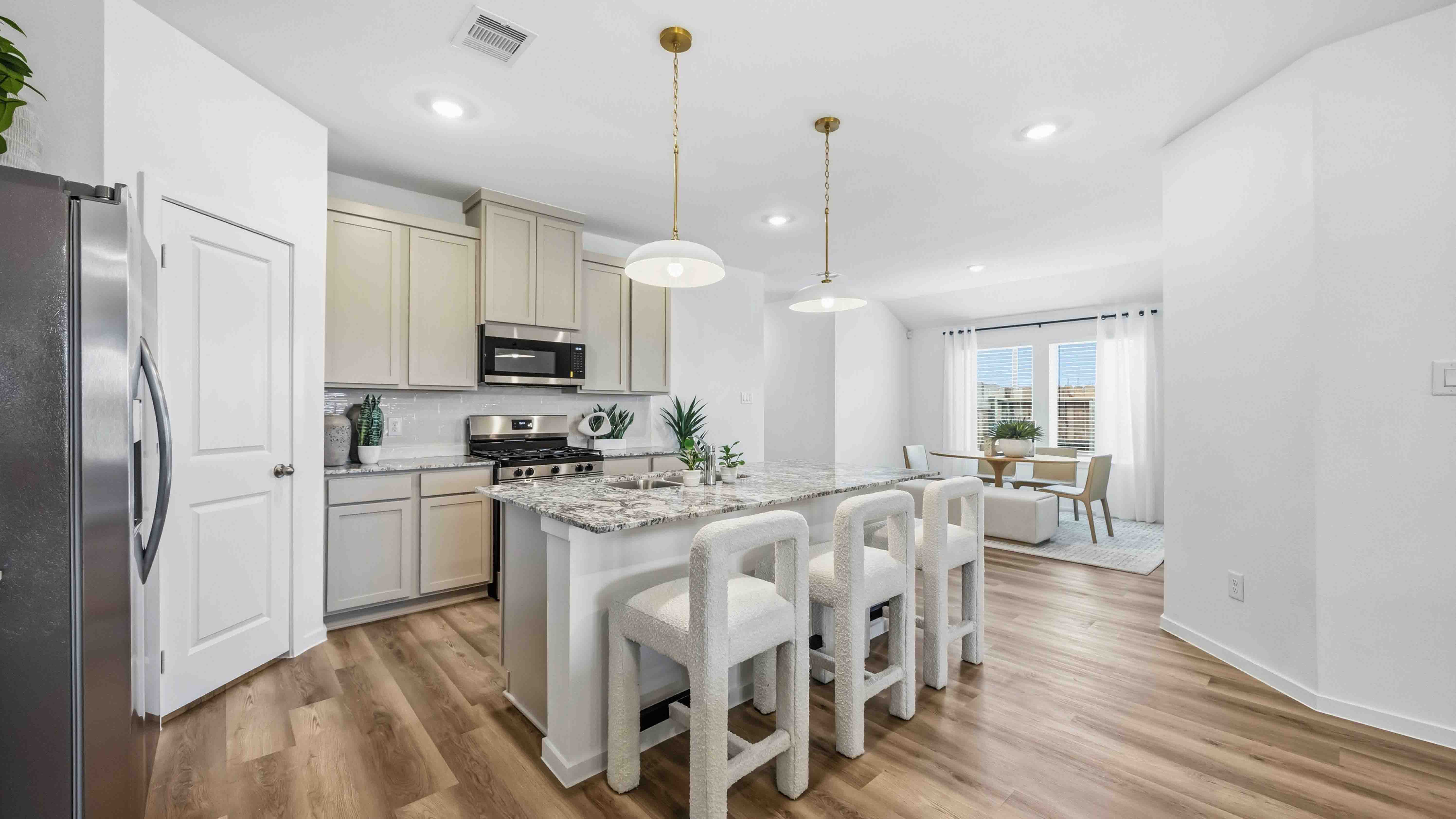 gorgeous kitchen with grey cabinets, light wood vinyl flooring, with stainless steel appliances