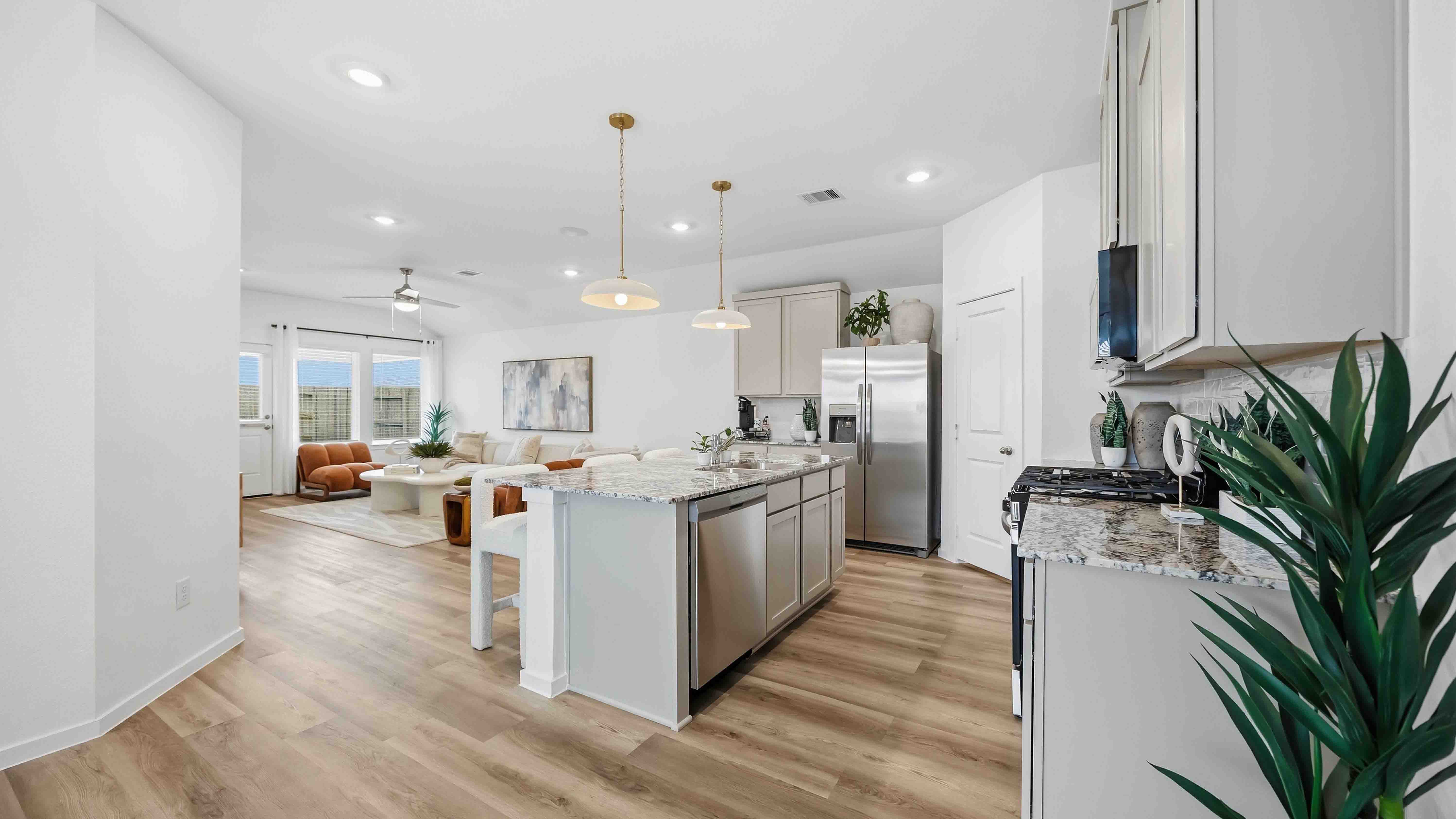 Bright and spacious kitchen with granite countertops, stainless steel appliances, and an island with bar seating