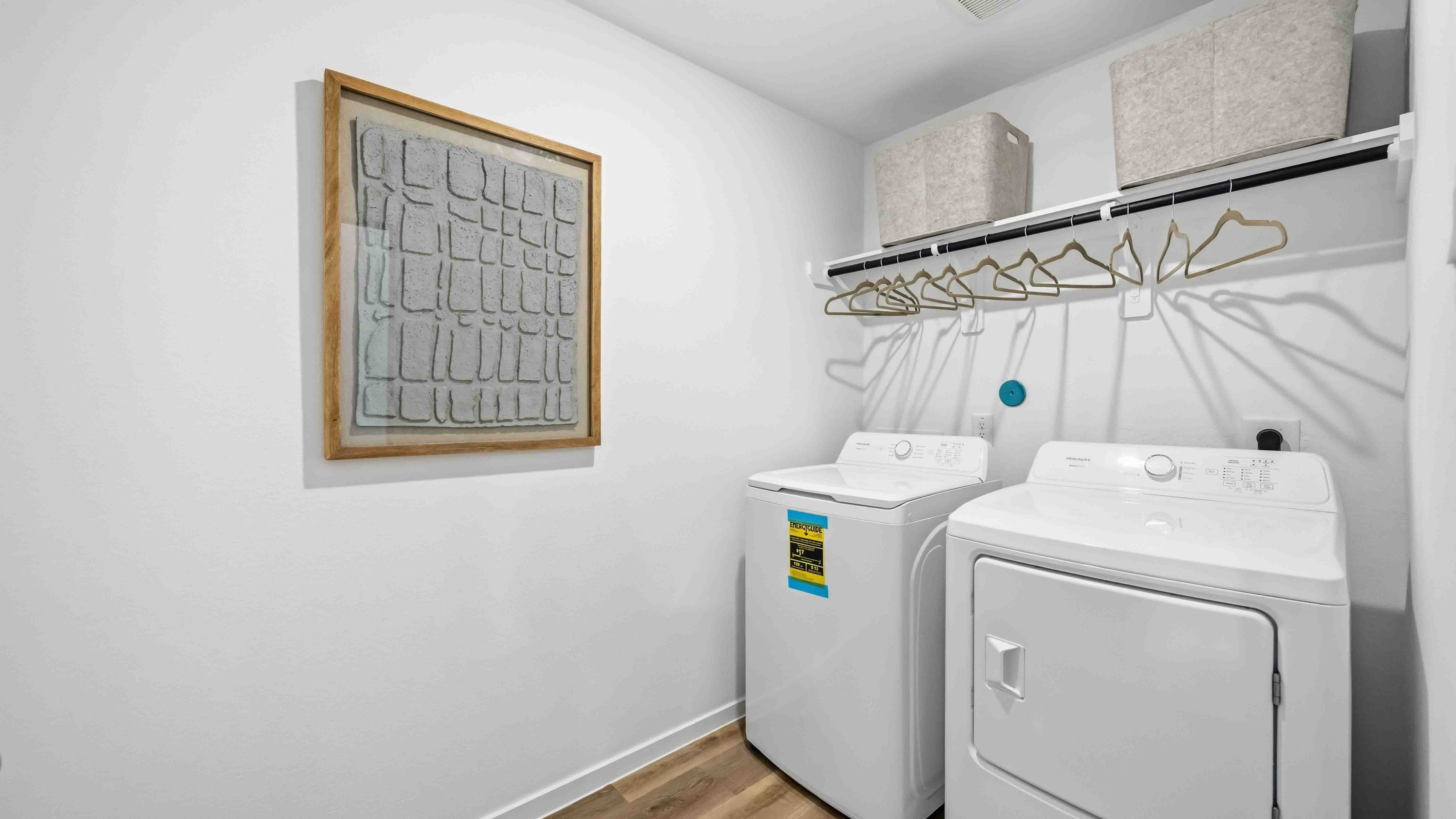 laundry room area with an open shelf and rod for additional storage and hanging clothes