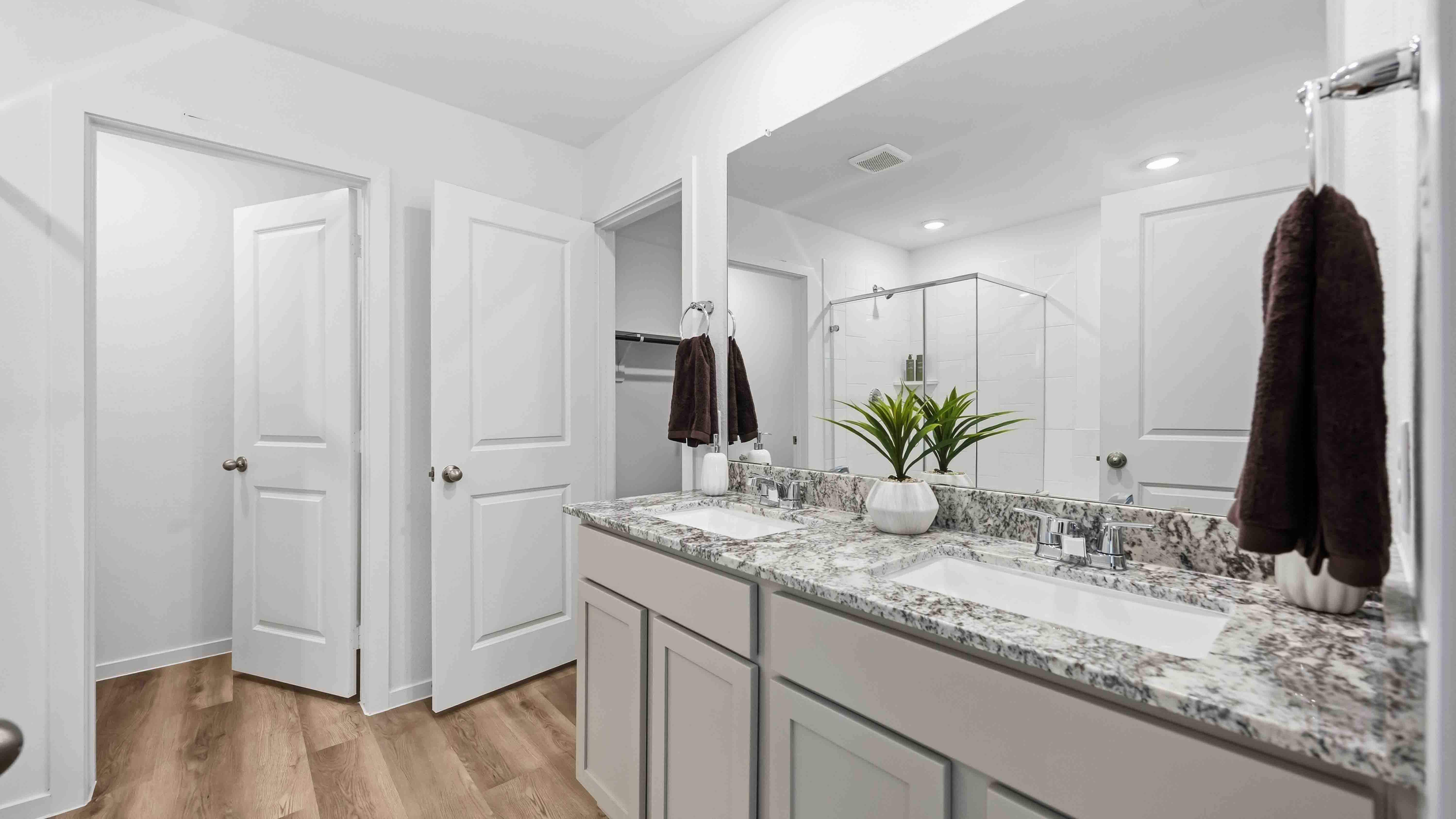 the en-suite primary bathroom has a double vanity and a standing shower