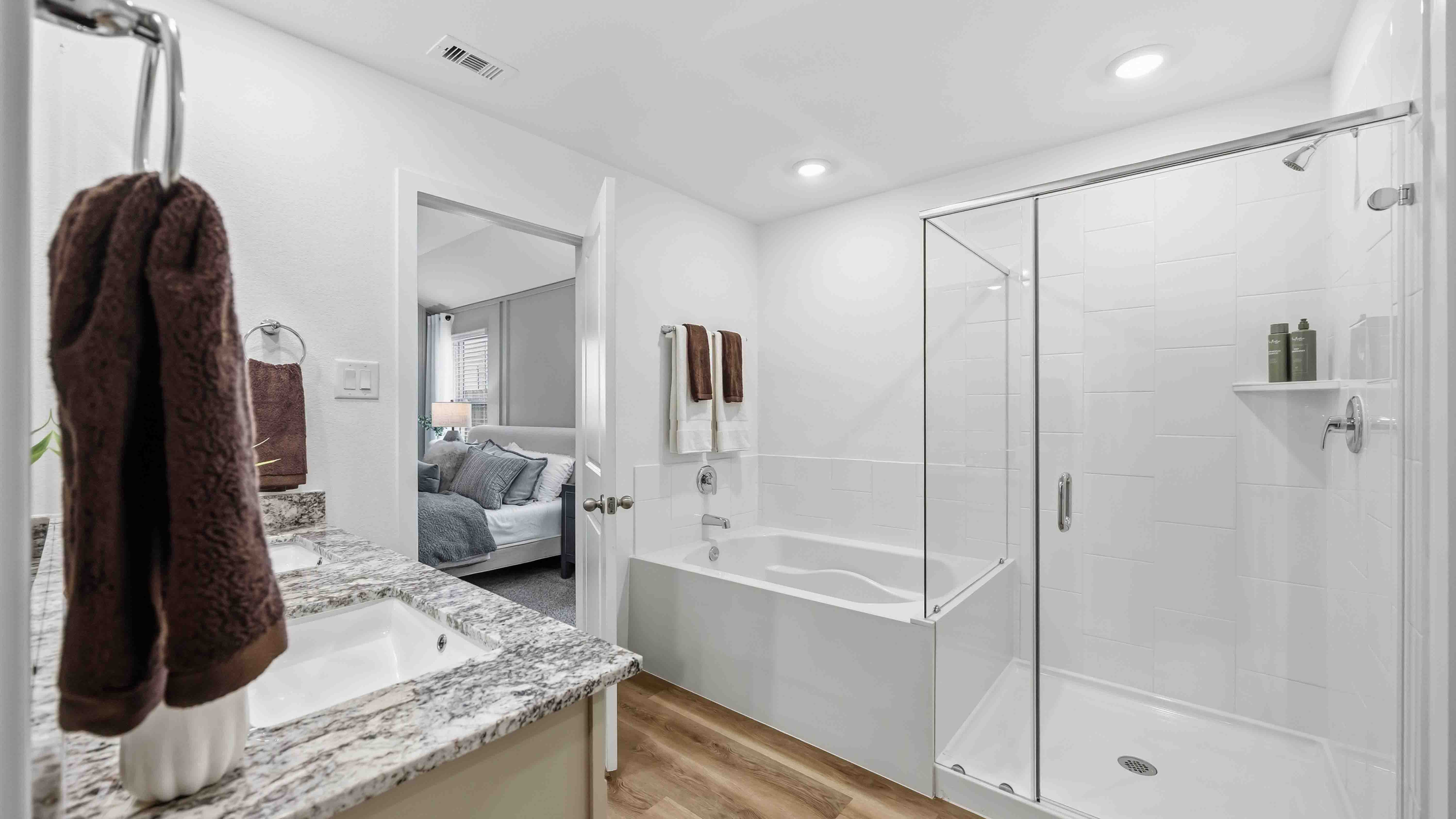 the en-suite primary bathroom has a double vanity and a standing shower