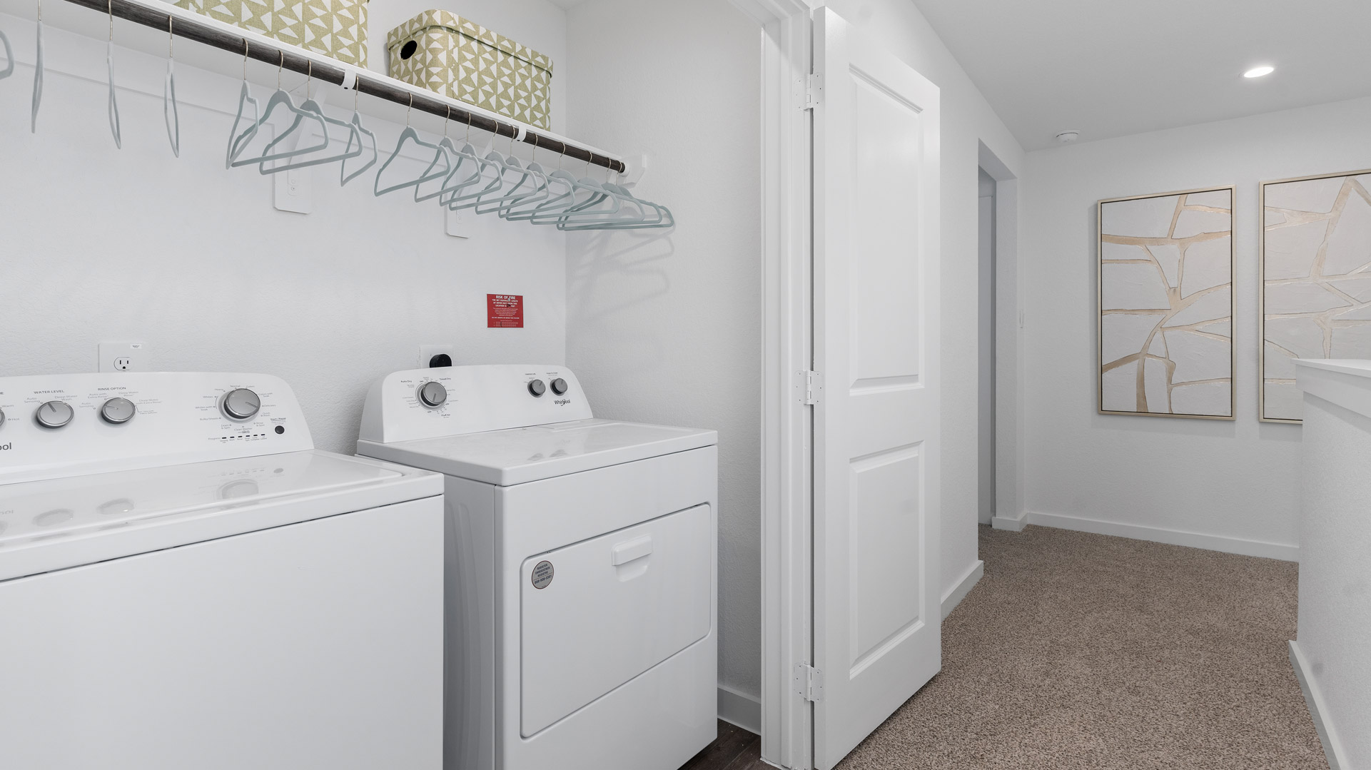 laundry room area with an open shelf and rod for additional storage and hanging clothes