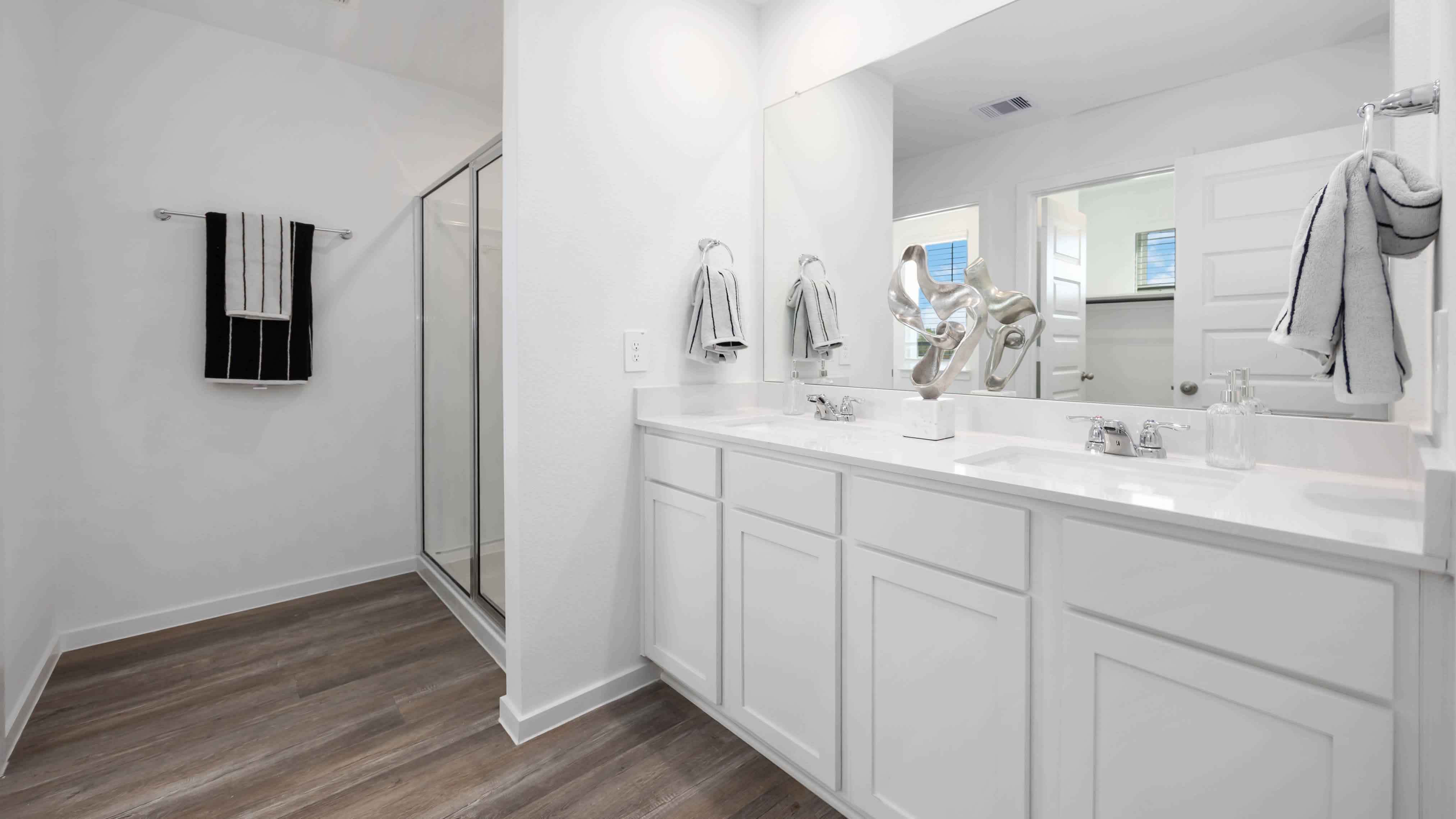 the en-suite primary bathroom has a double vanity and spacious walk-in closet