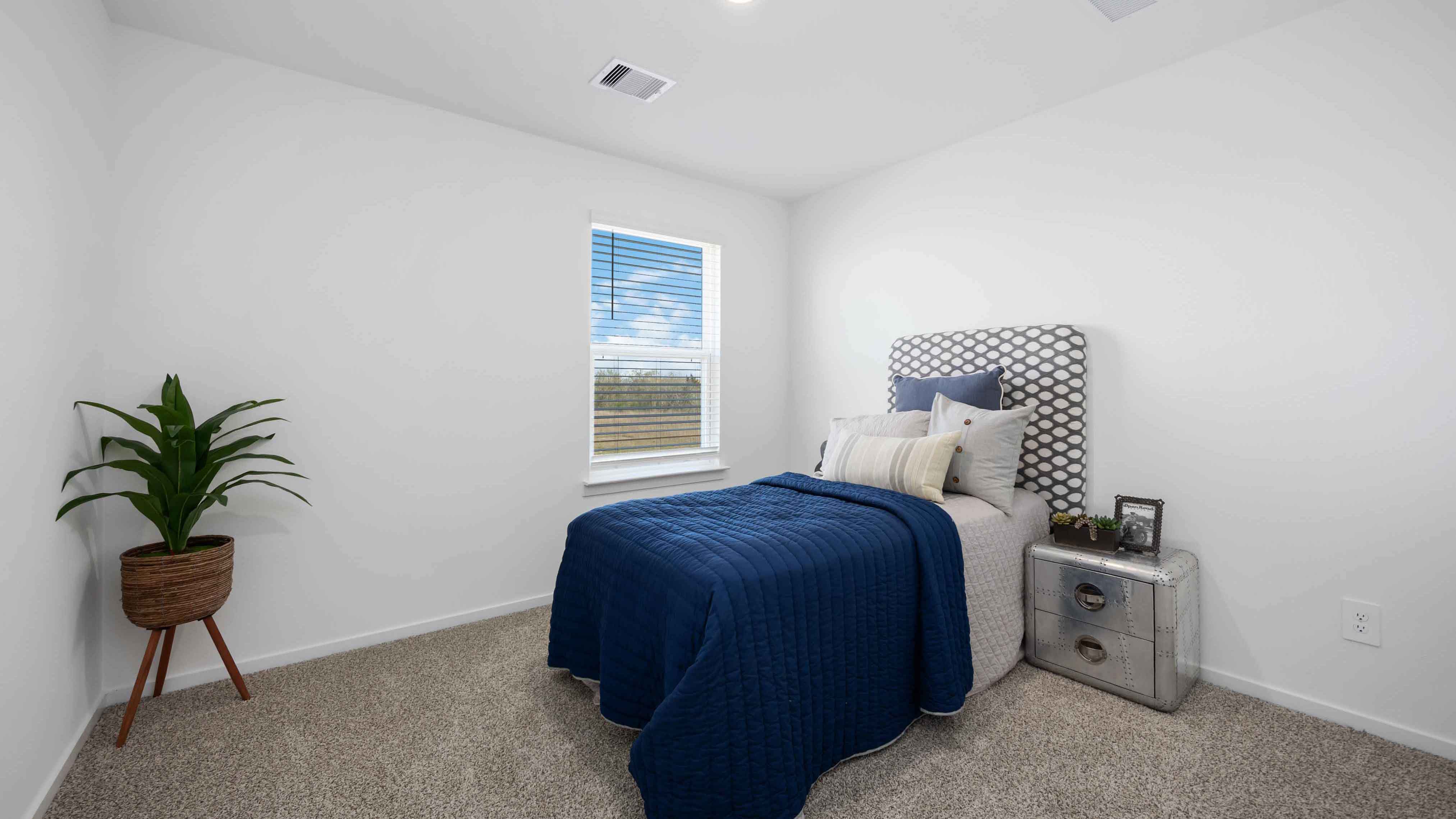 third bedroom has light neutral walls and carpet flooring