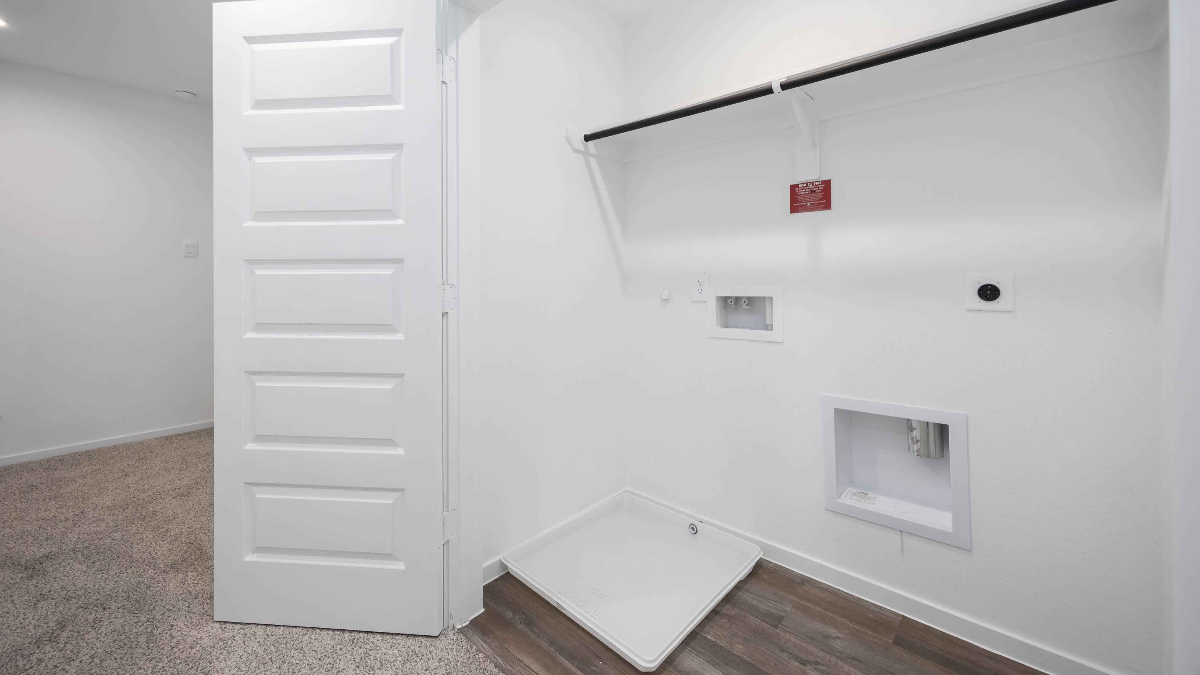 laundry room area with an open shelf and rod for additional storage and hanging clothes