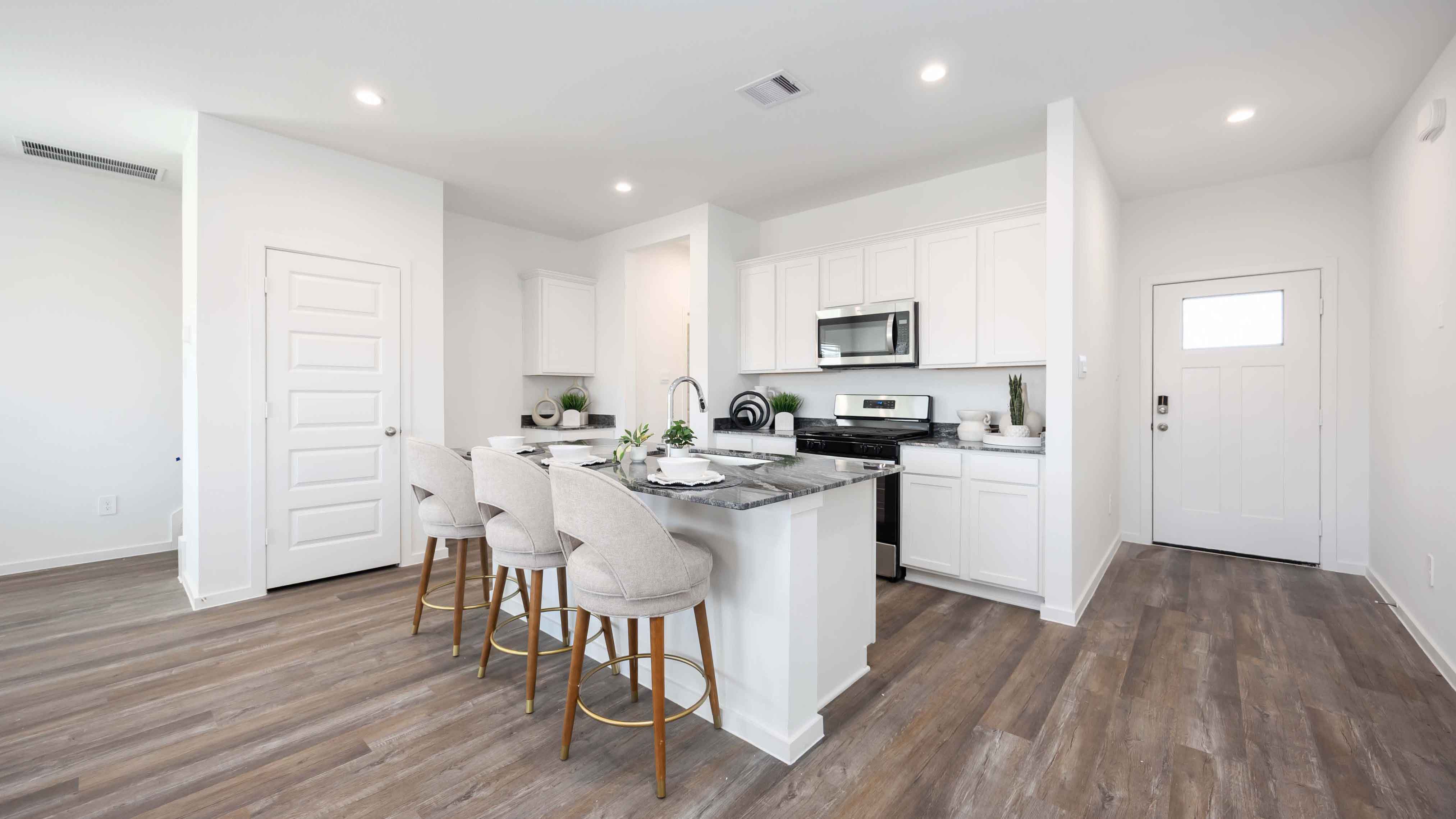 beautiful new kitchen with quartz counters, navy cabinets, and herringbone backsplash