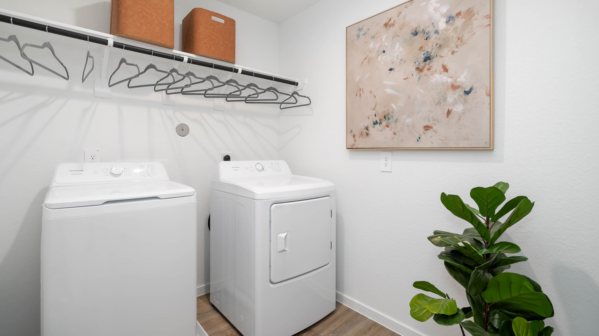 laundry room area with an open shelf and rod for additional storage and hanging clothes