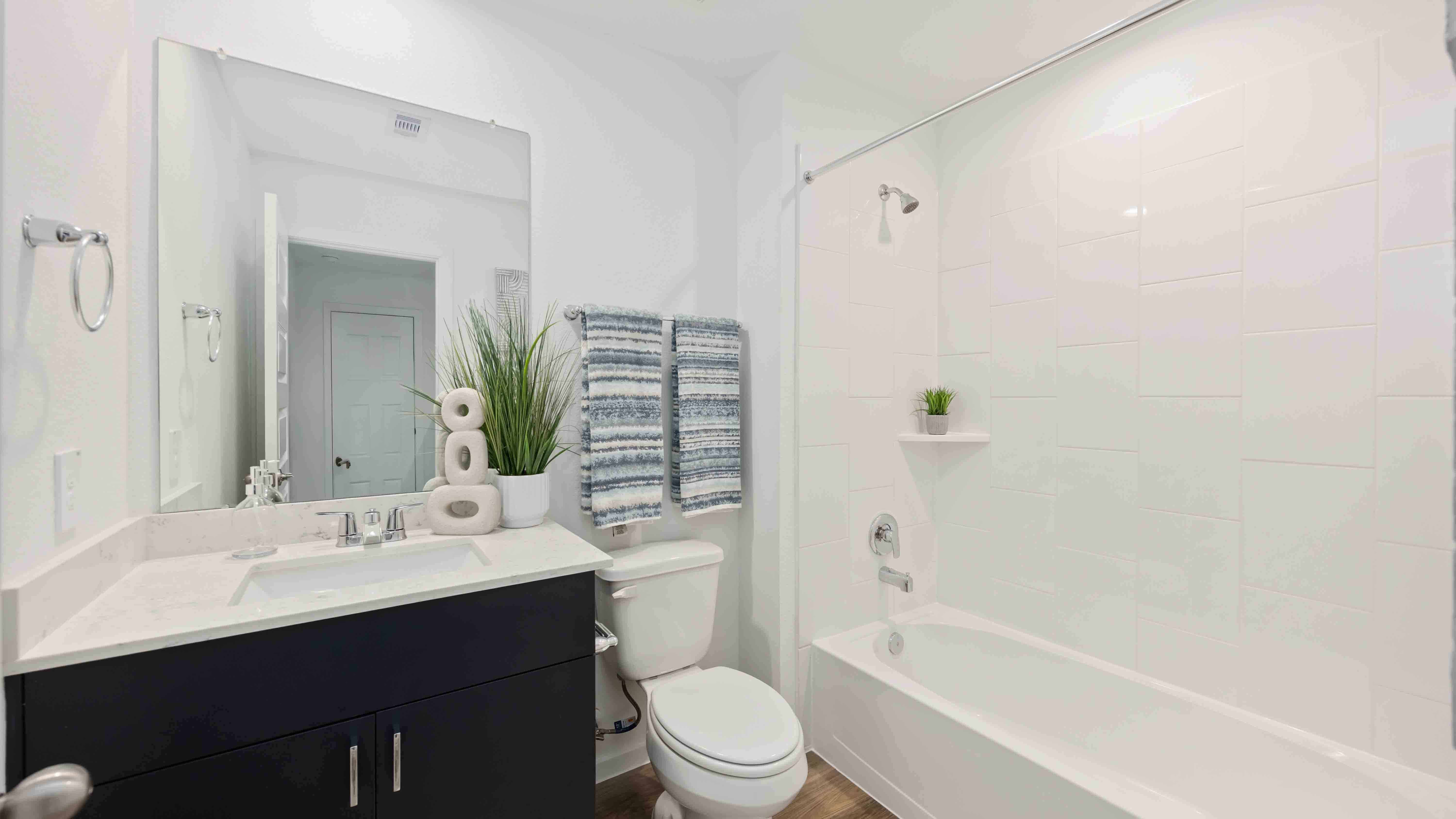 a spacious secondary bathroom with one sink vanity and standing tub