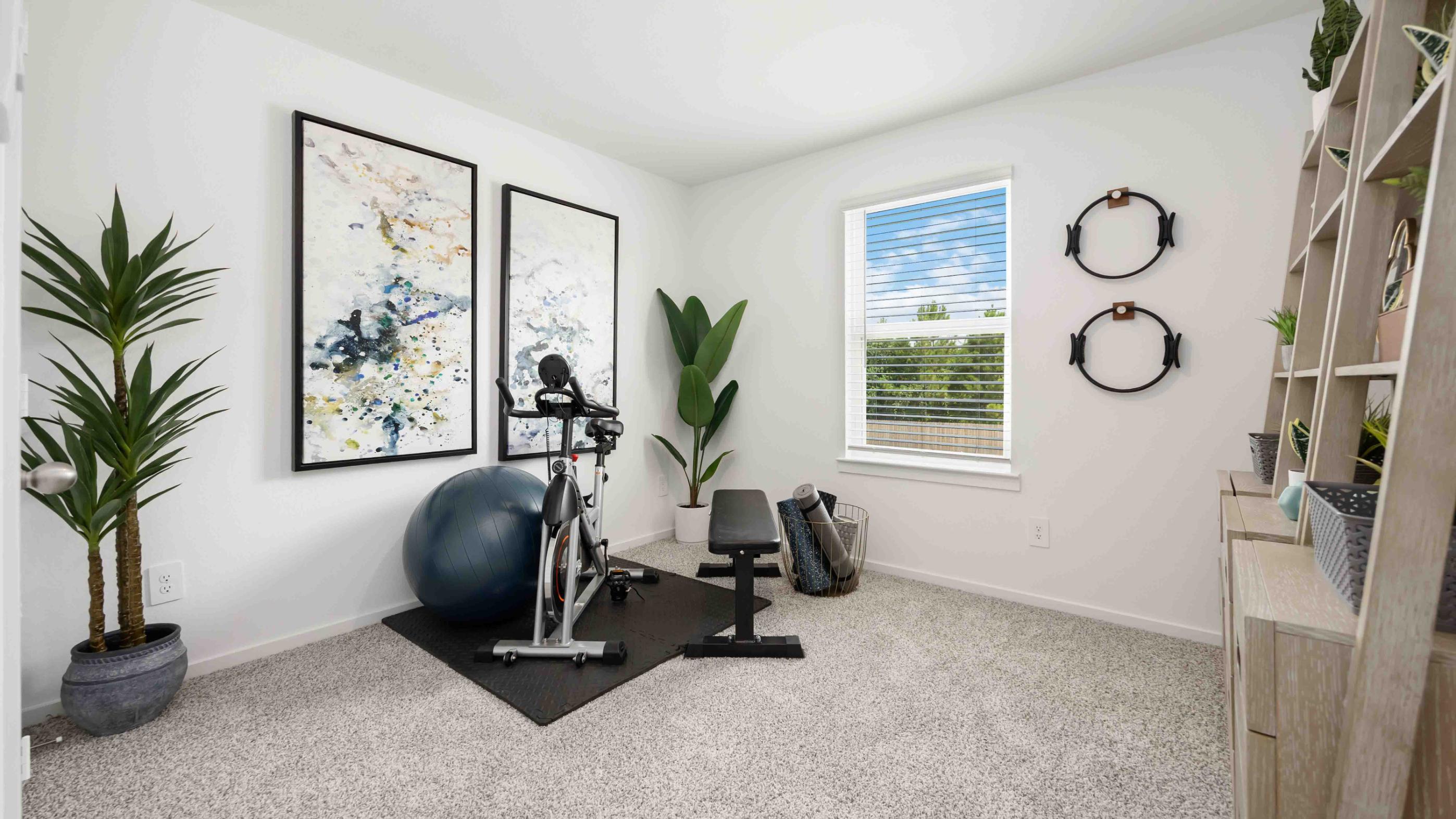 home gym/third bedroom has light neutral walls and carpet flooring