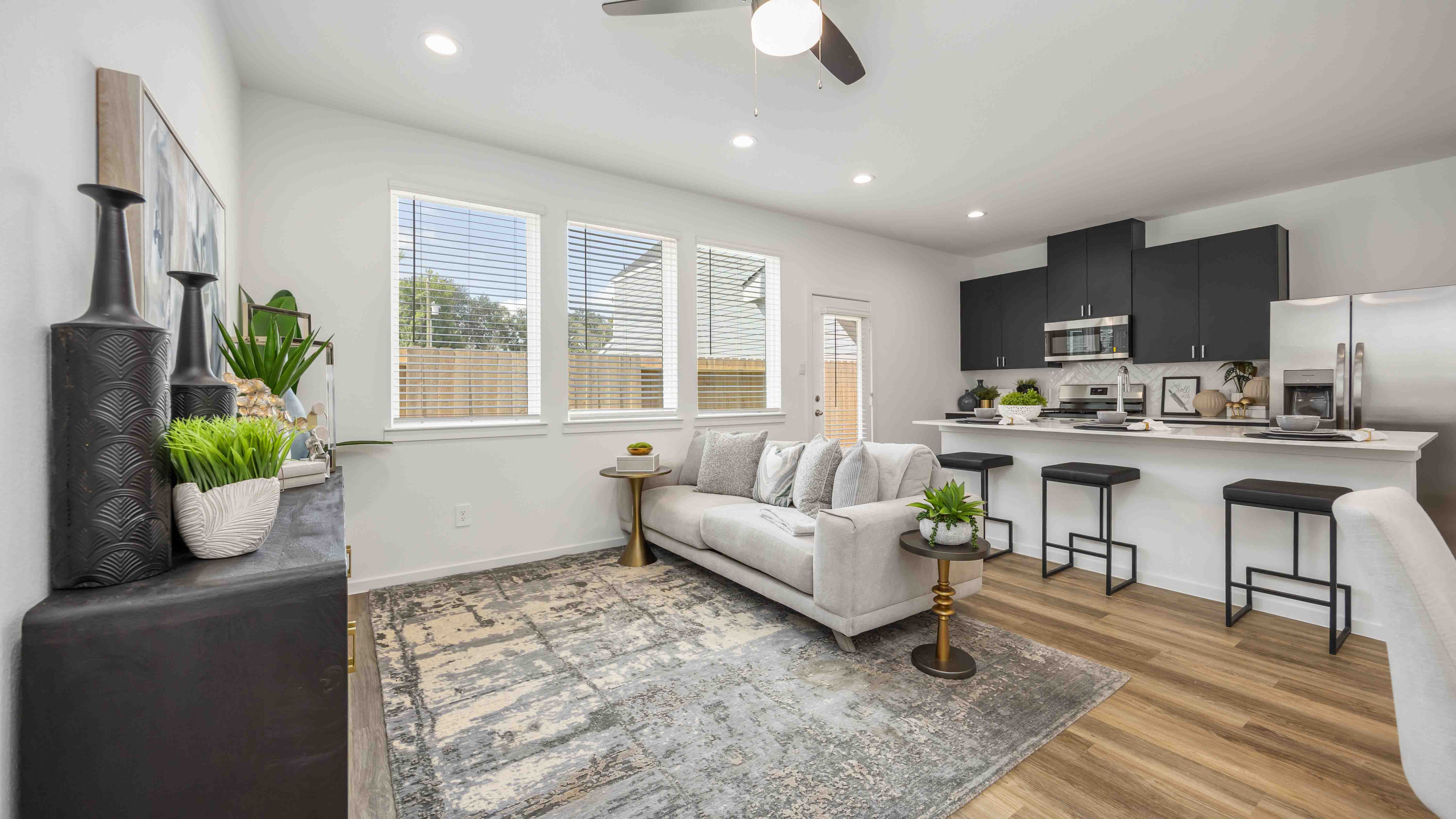 a well-organized living room that includes a kitchen and dining area, creating a warm and welcoming environment for gatherings