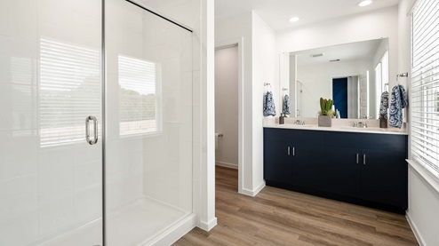 alaia crossing model home en-suite primary bathroom with walk-in shower and double vanity