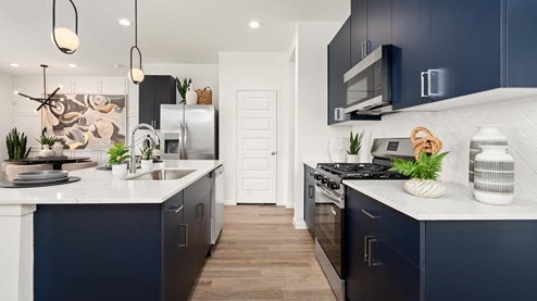 alaia crossing model home kitchen with navy cabinets and quartz countertops