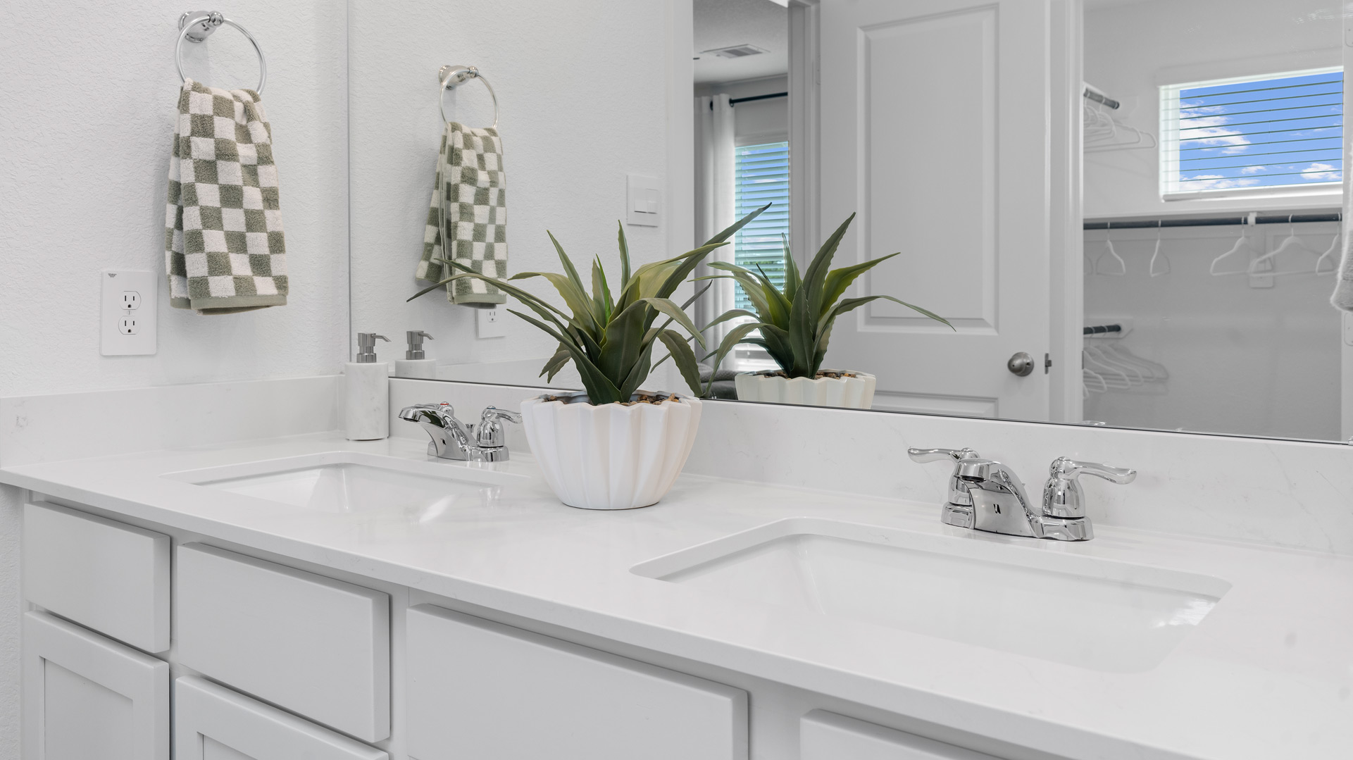a large mirror is located above the double vanity in the primary bathroom