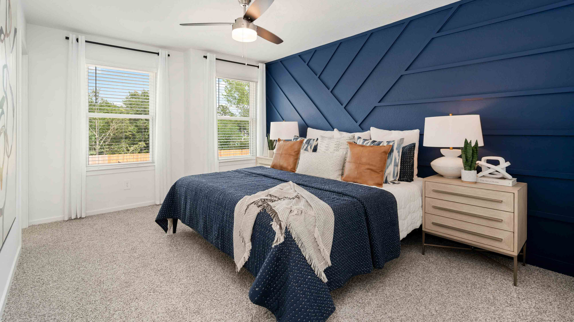 spacious primary bedroom with two tall windows for natural light