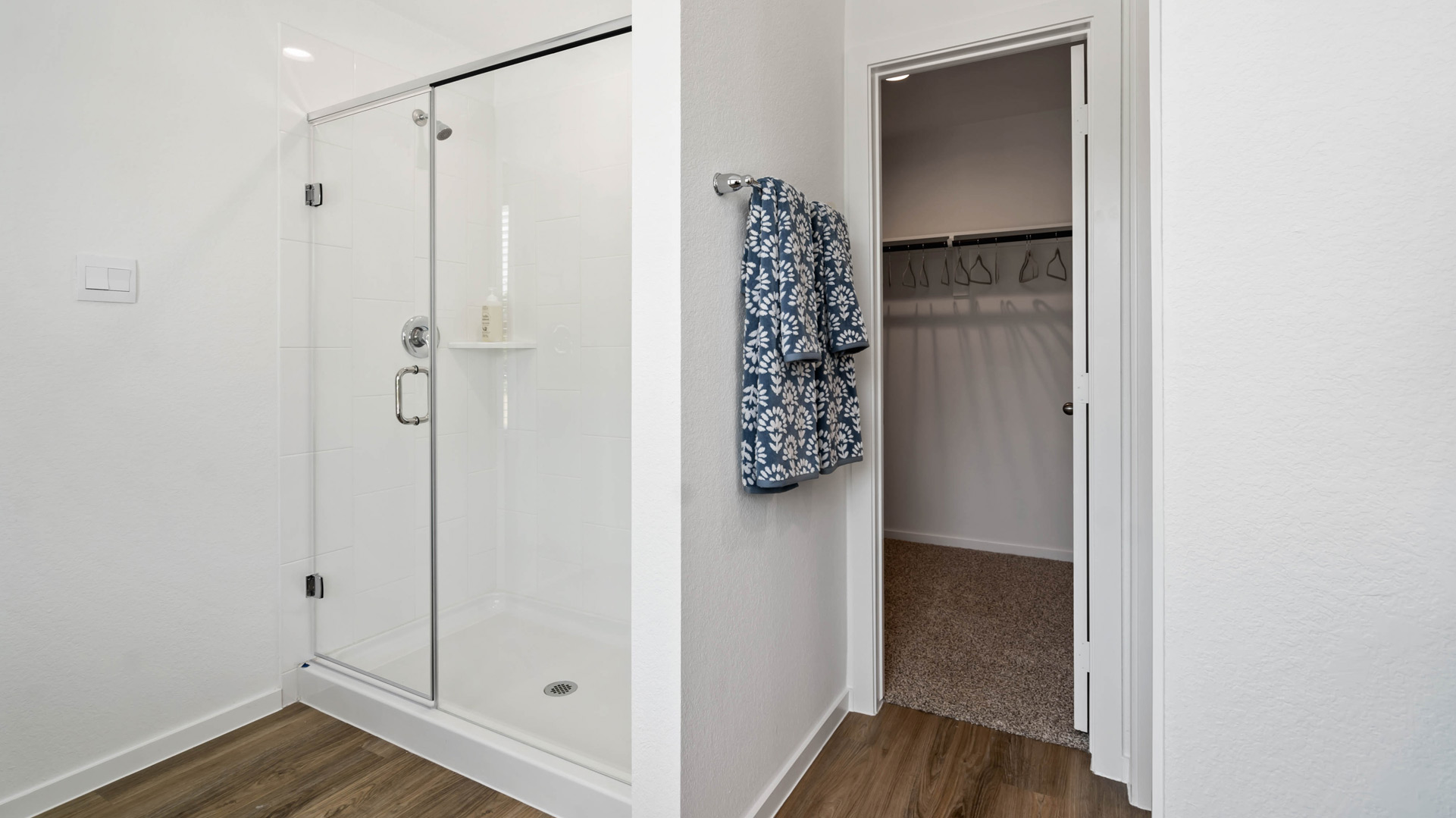 primary bathroom has a walk-in shower with tiled walls and glass enclosure