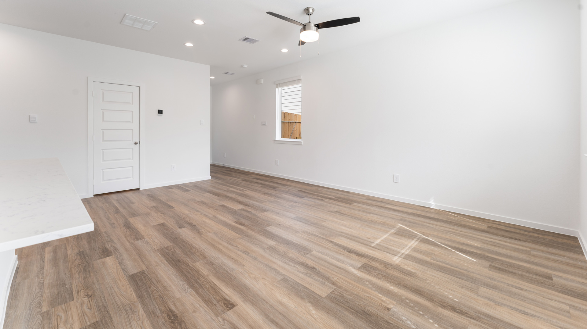 living room with a ceiling fan installed and revwood laminate flooring