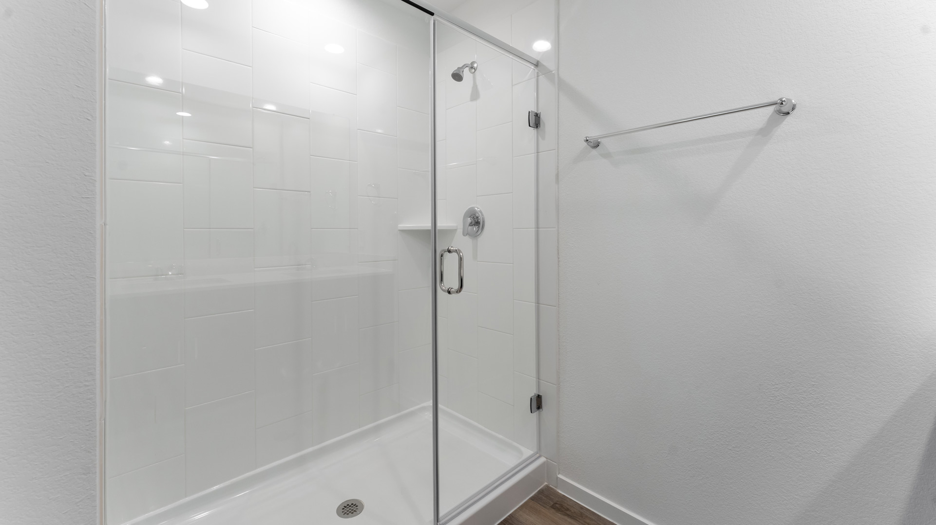 the primary bathroom features a walk-in shower with tiled walls and a glass surround