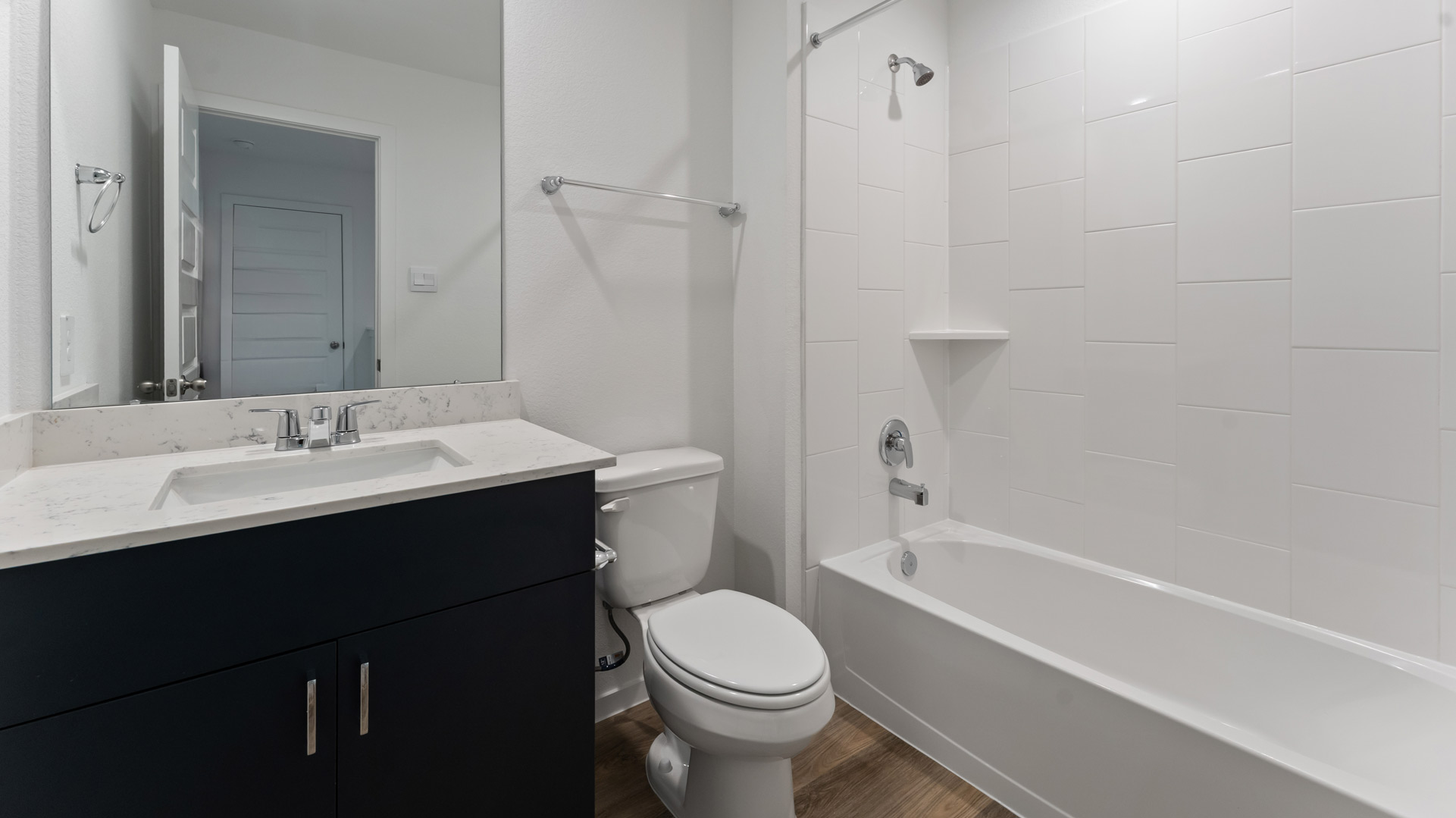 a second full bathroom is located upstairs and has a mirror over a single vanity and a shower/tub combo