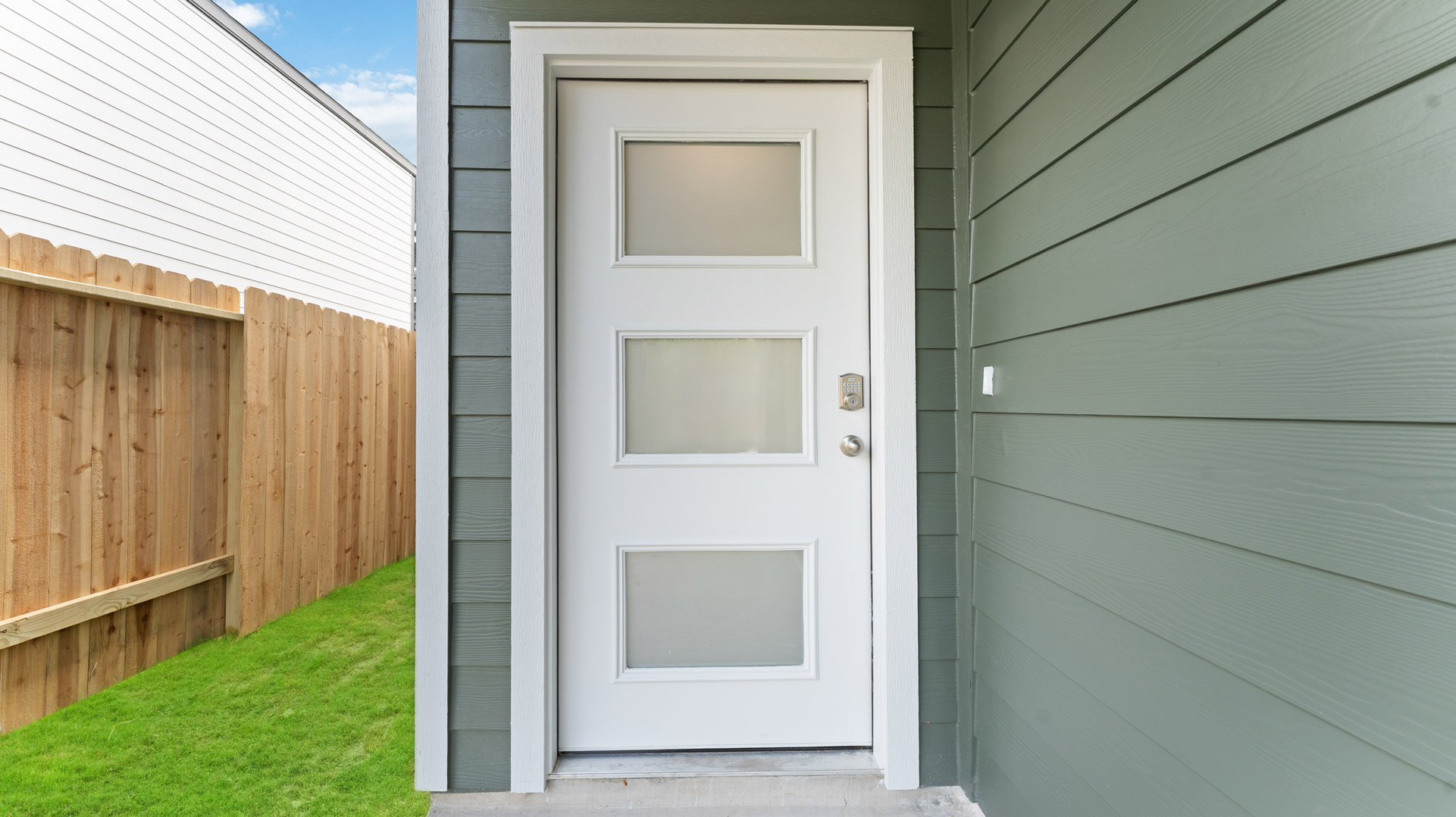 front door entry into the dove plan with an elevated front door that has a modern design with 3 glass inserts