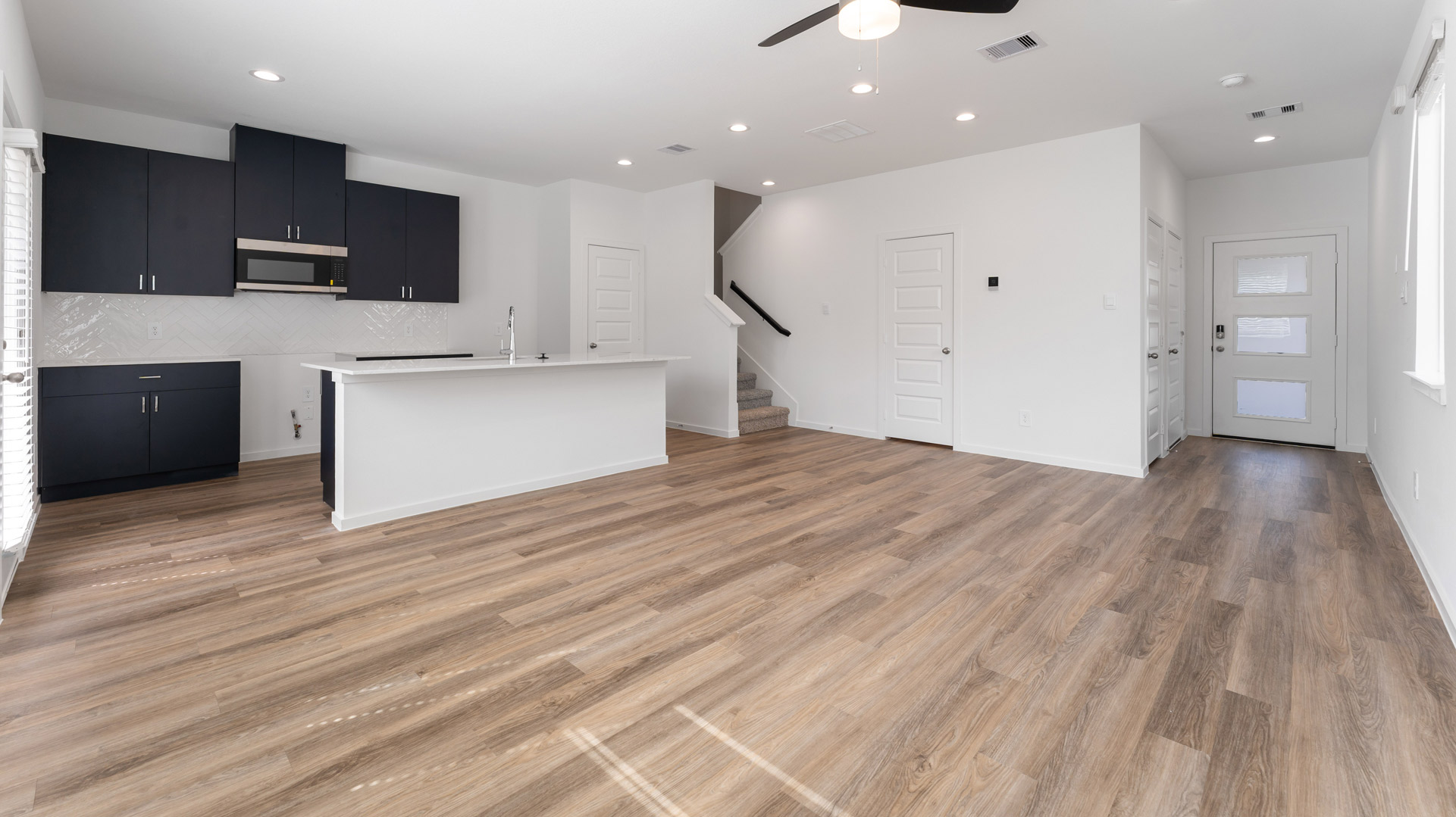 enter into the open concept living on the main floor where the living room, kitchen, and dining areas are open to eachother