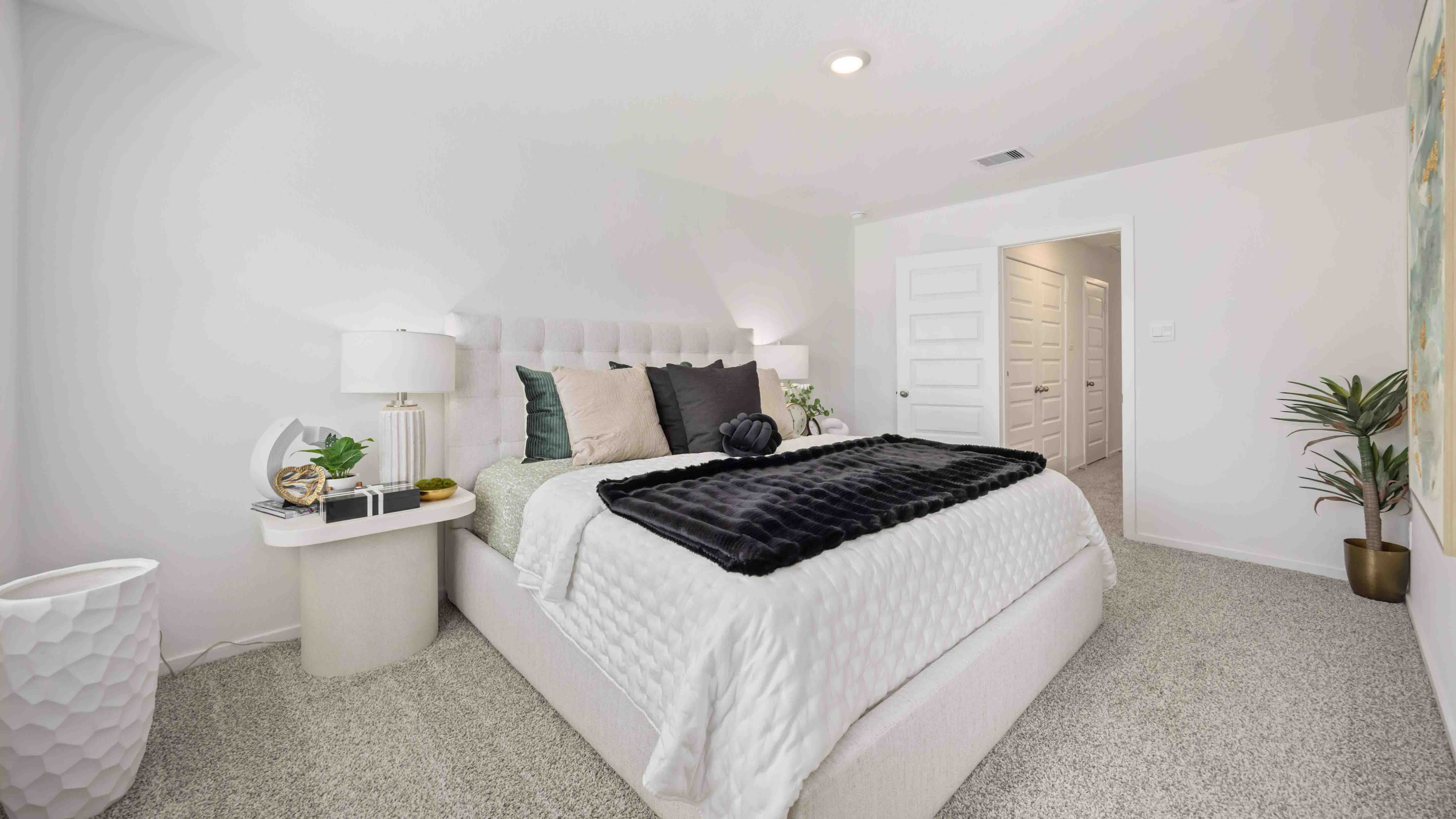 a spacious primary suite comfortably fits a king size bed and additional bedroom furniture