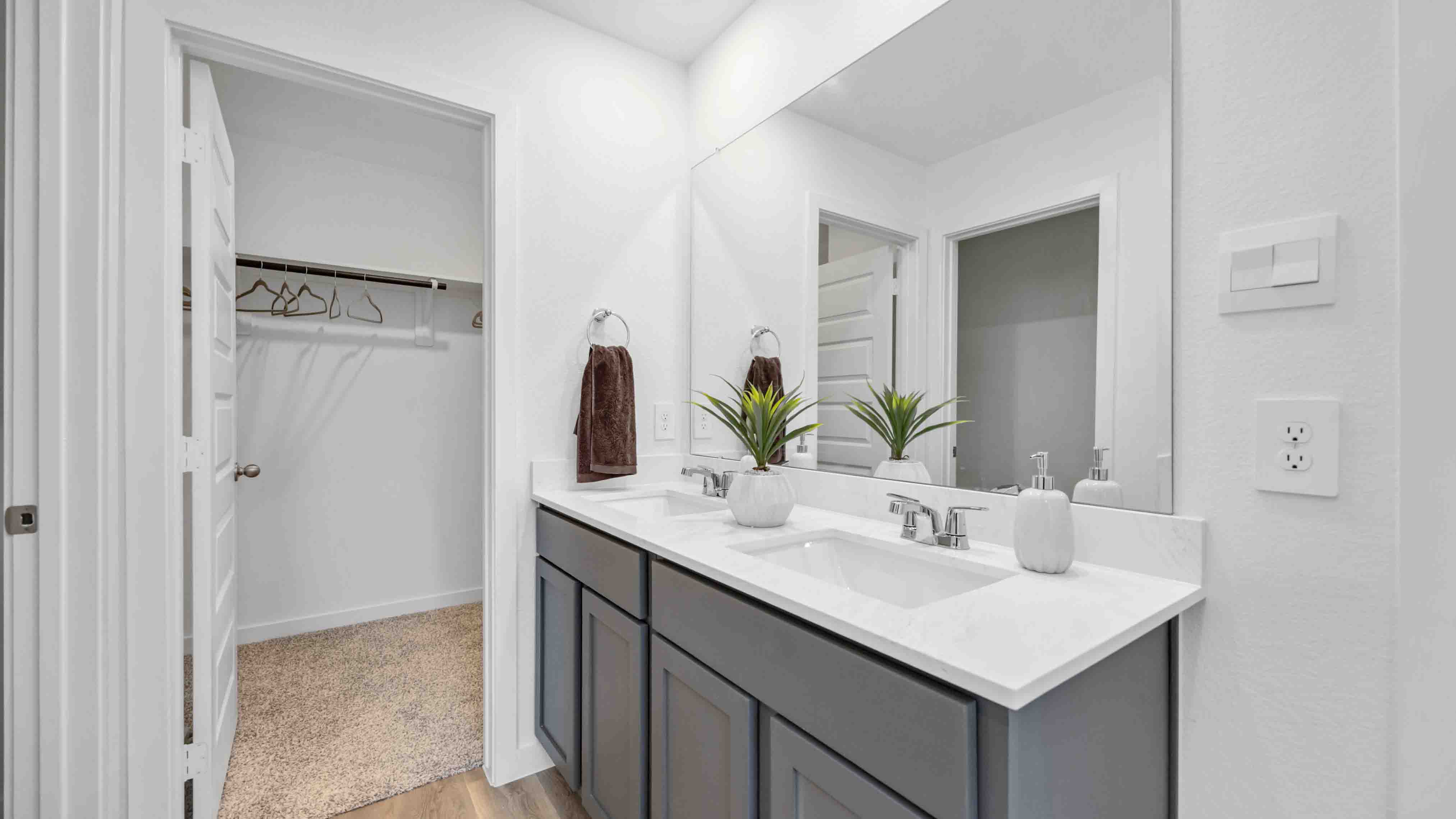 the en-suite primary bathroom has a double vanity and spacious walk-in closet