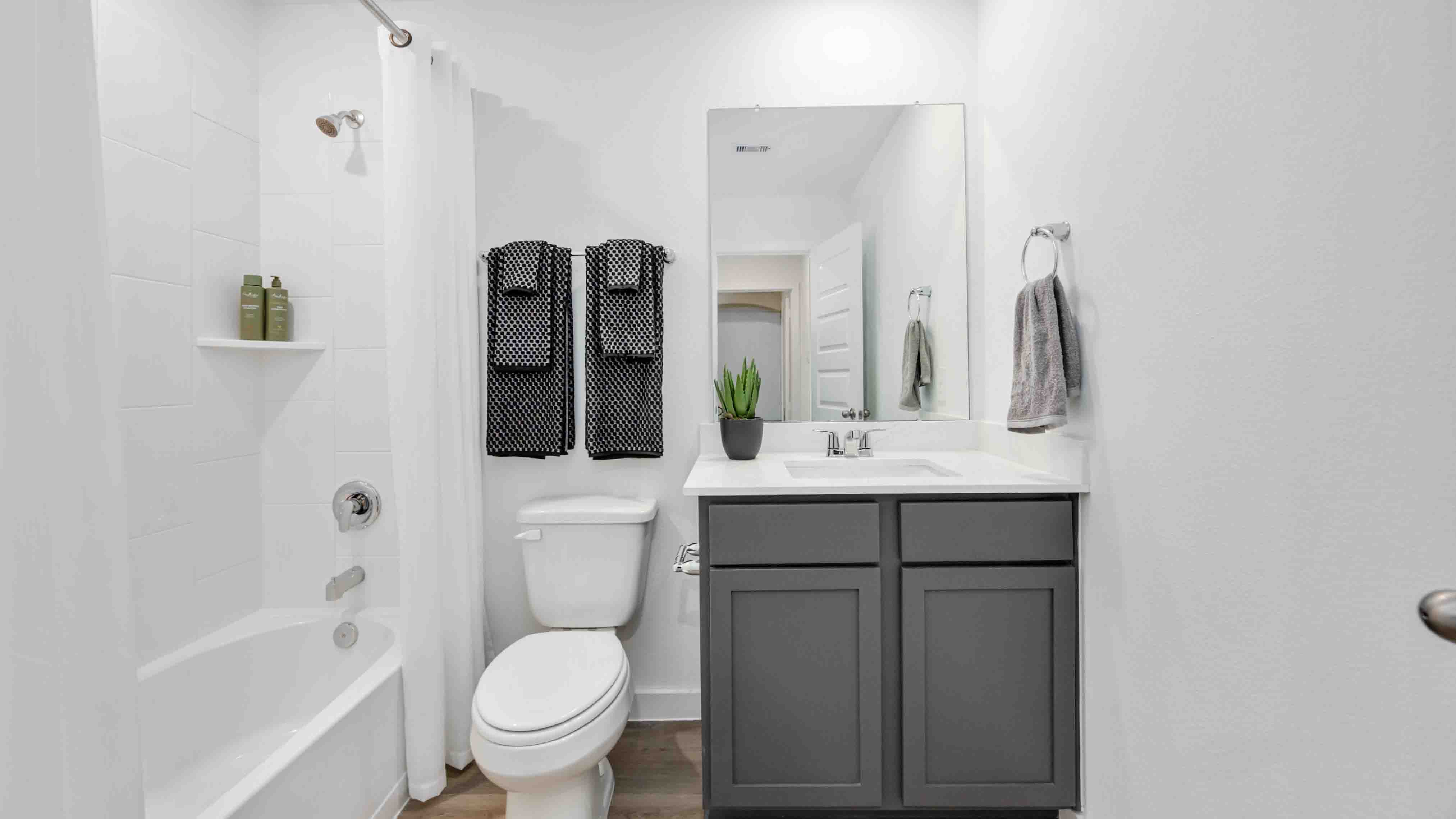a spacious secondary bathroom with one sink vanity and standing tub
