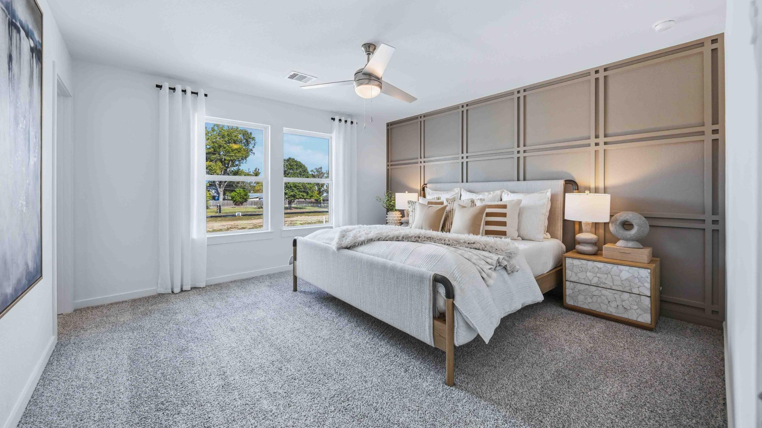 a spacious primary suite comfortably fits a king size bed and additional bedroom furniture