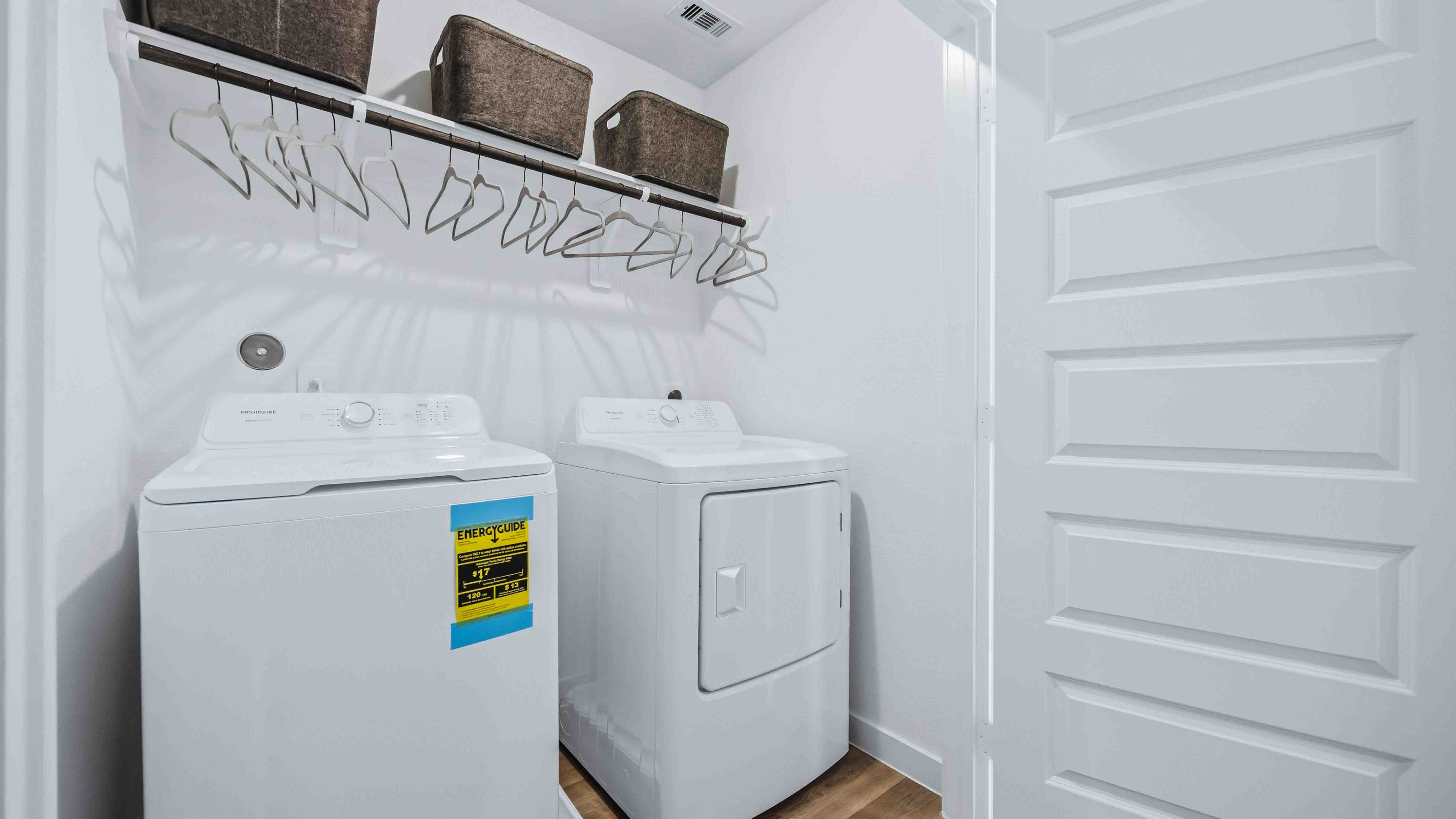laundry room area with an open shelf and rod for additional storage and hanging clothes