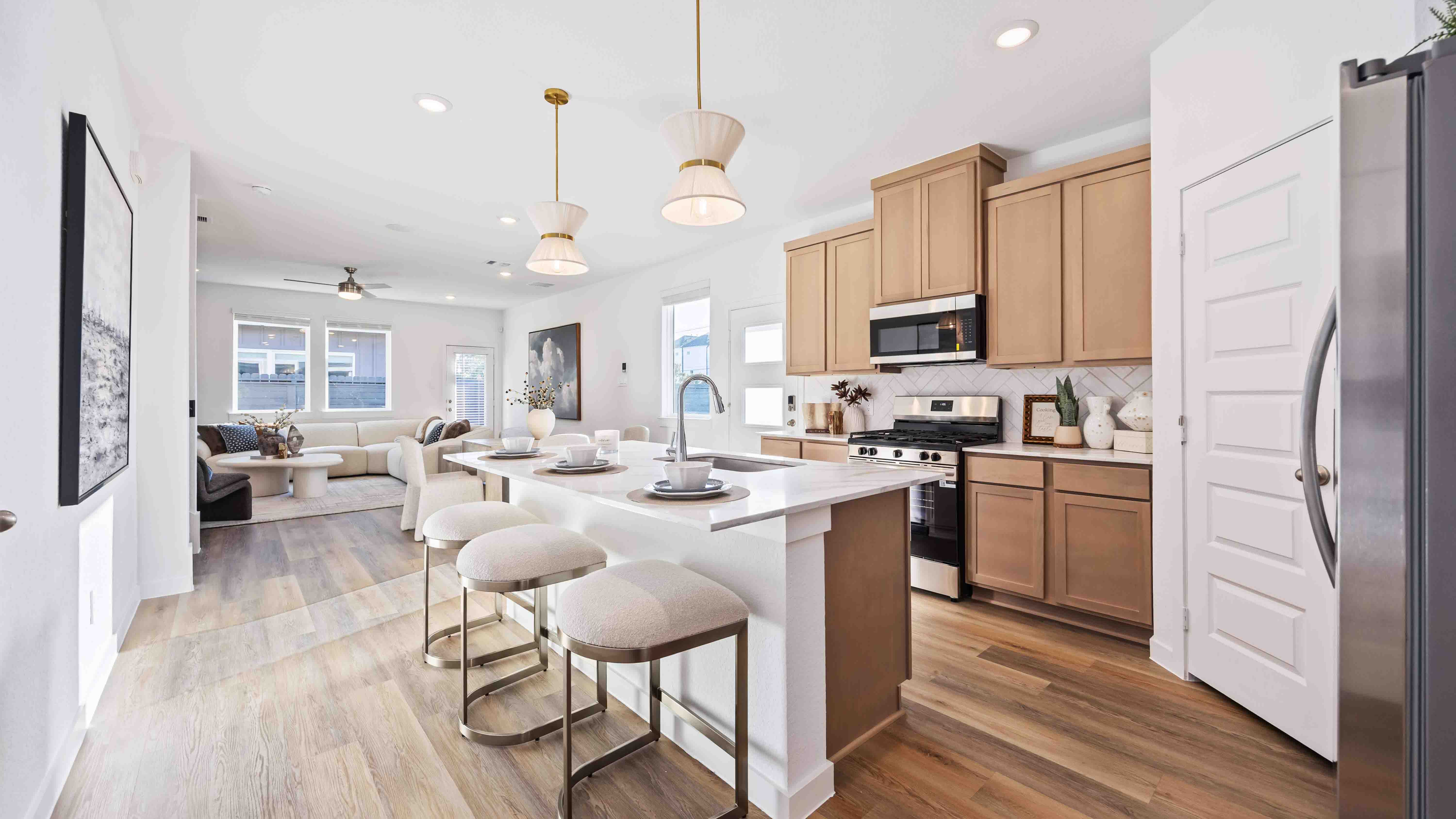 kitchen off the front door with natural wood colored cabinets