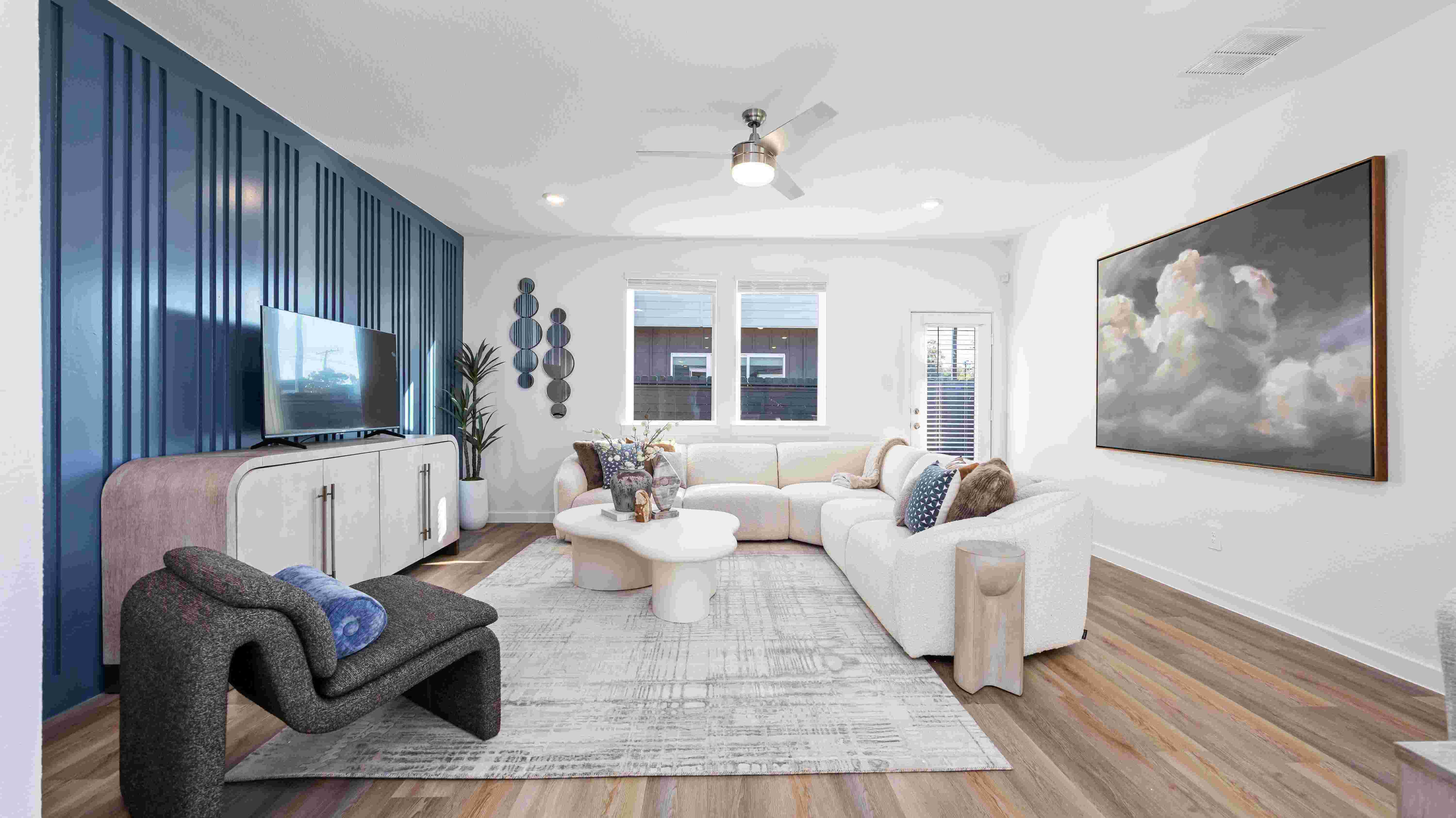 spacious living room area with windows overlooking the backyard