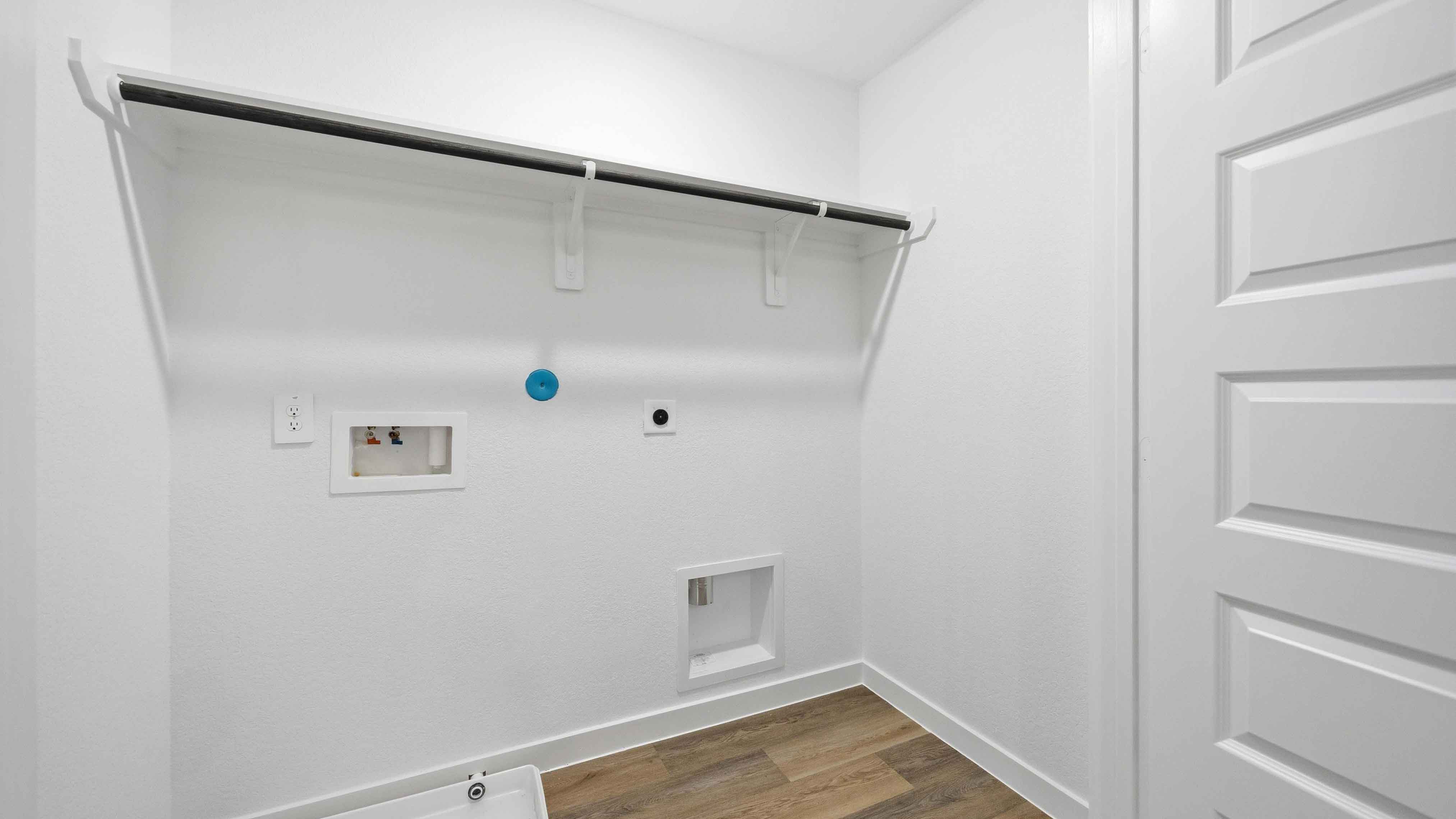 laundry room area with an open shelf and rod for additional storage and hanging clothes