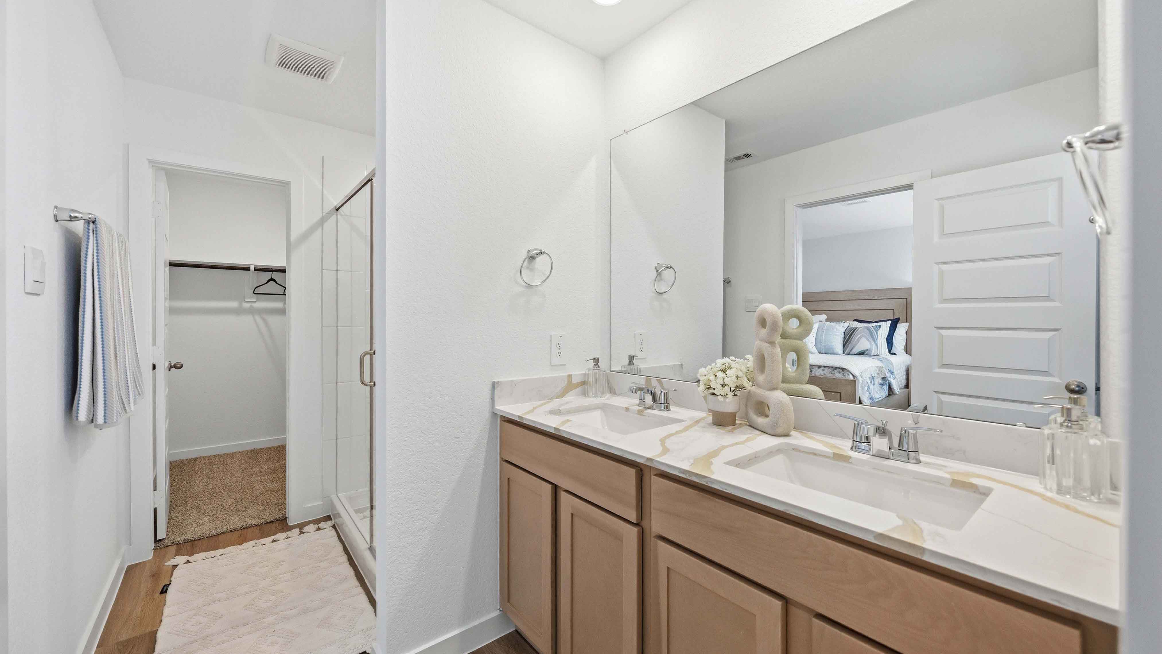 the en-suite primary bathroom has a double vanity and spacious walk-in closet
