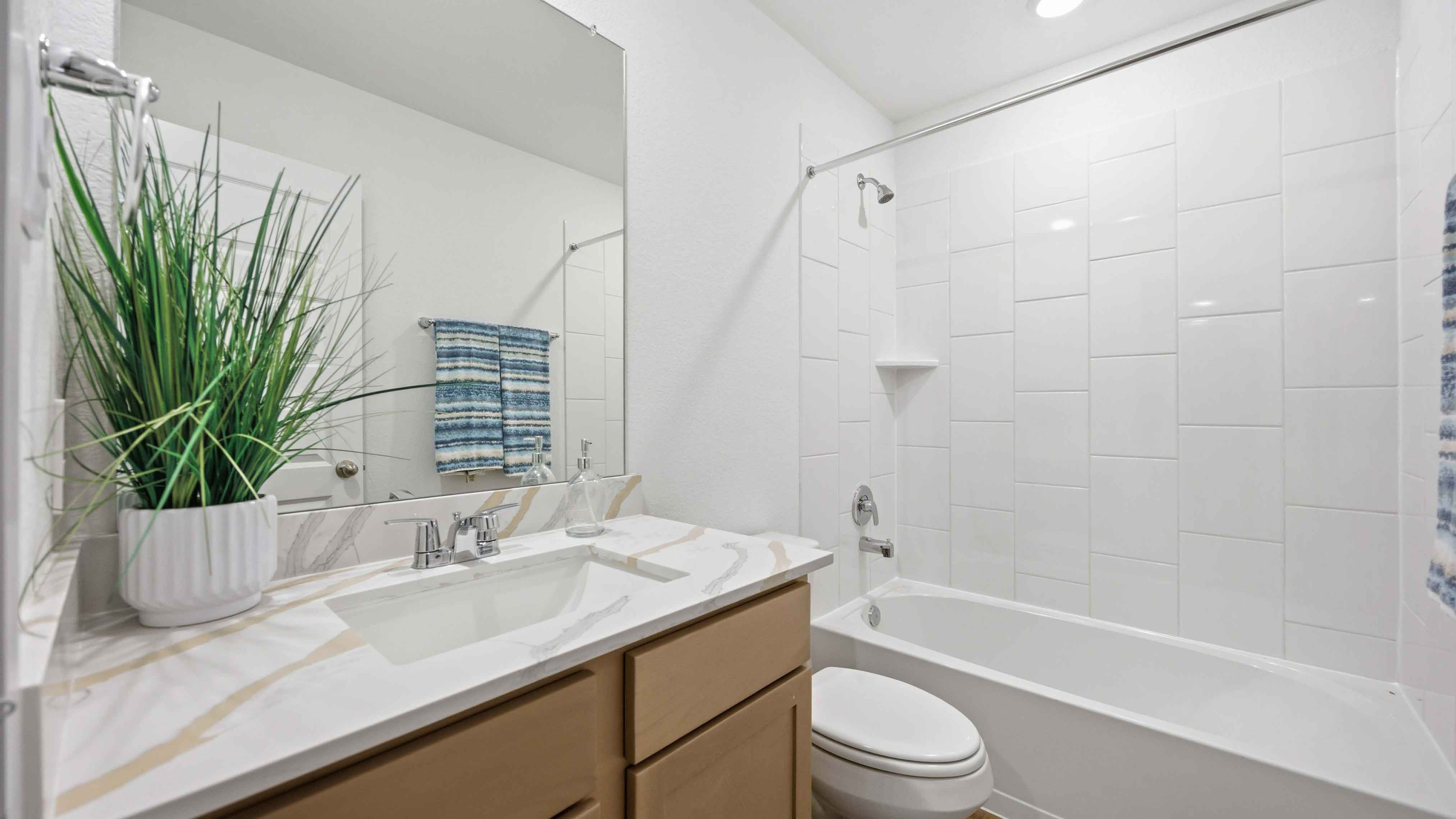 a spacious secondary bathroom with one sink vanity and standing tub