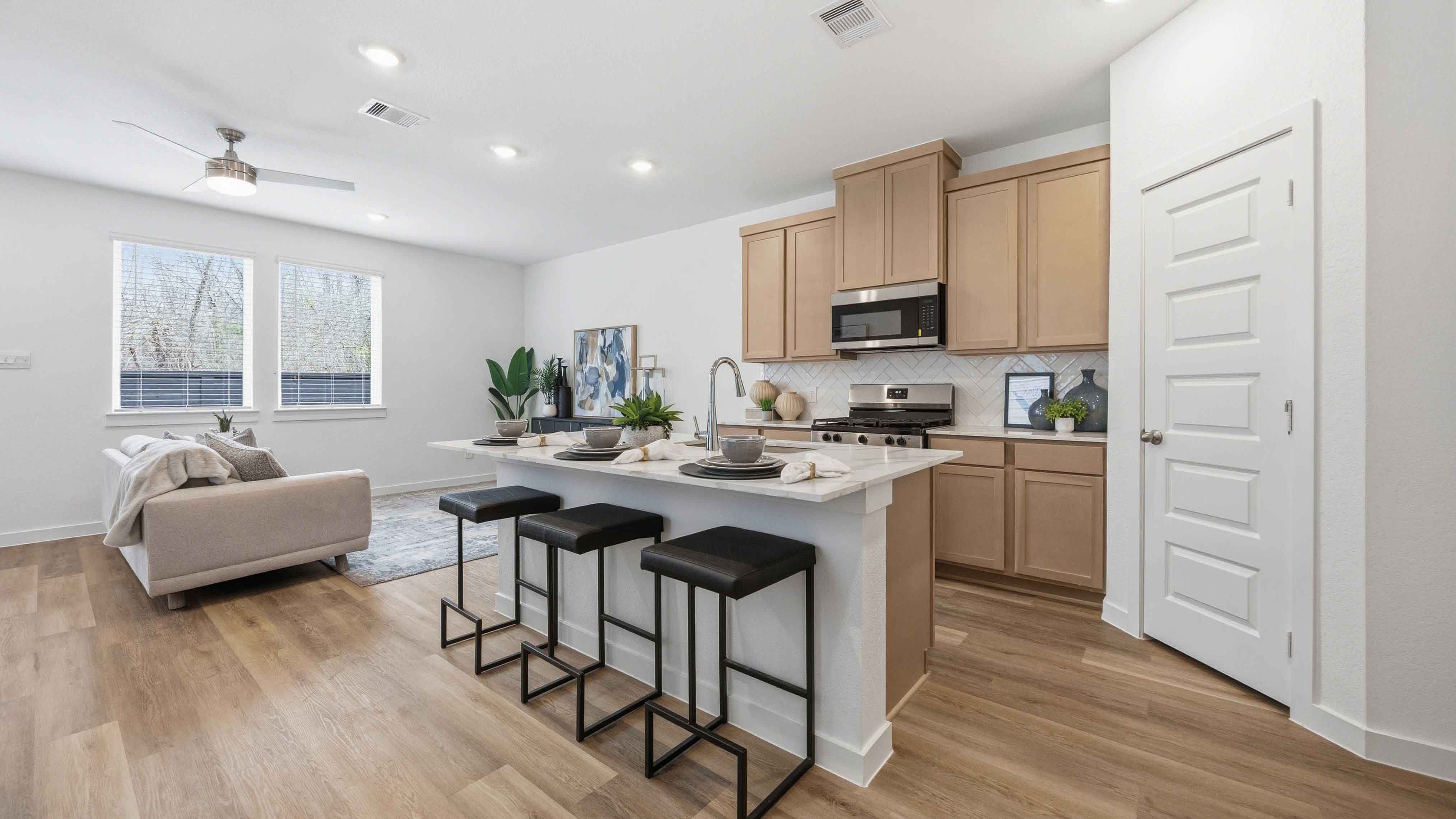 beautiful new kitchen with quartz counters, wood colored cabinets, and herringbone backsplash