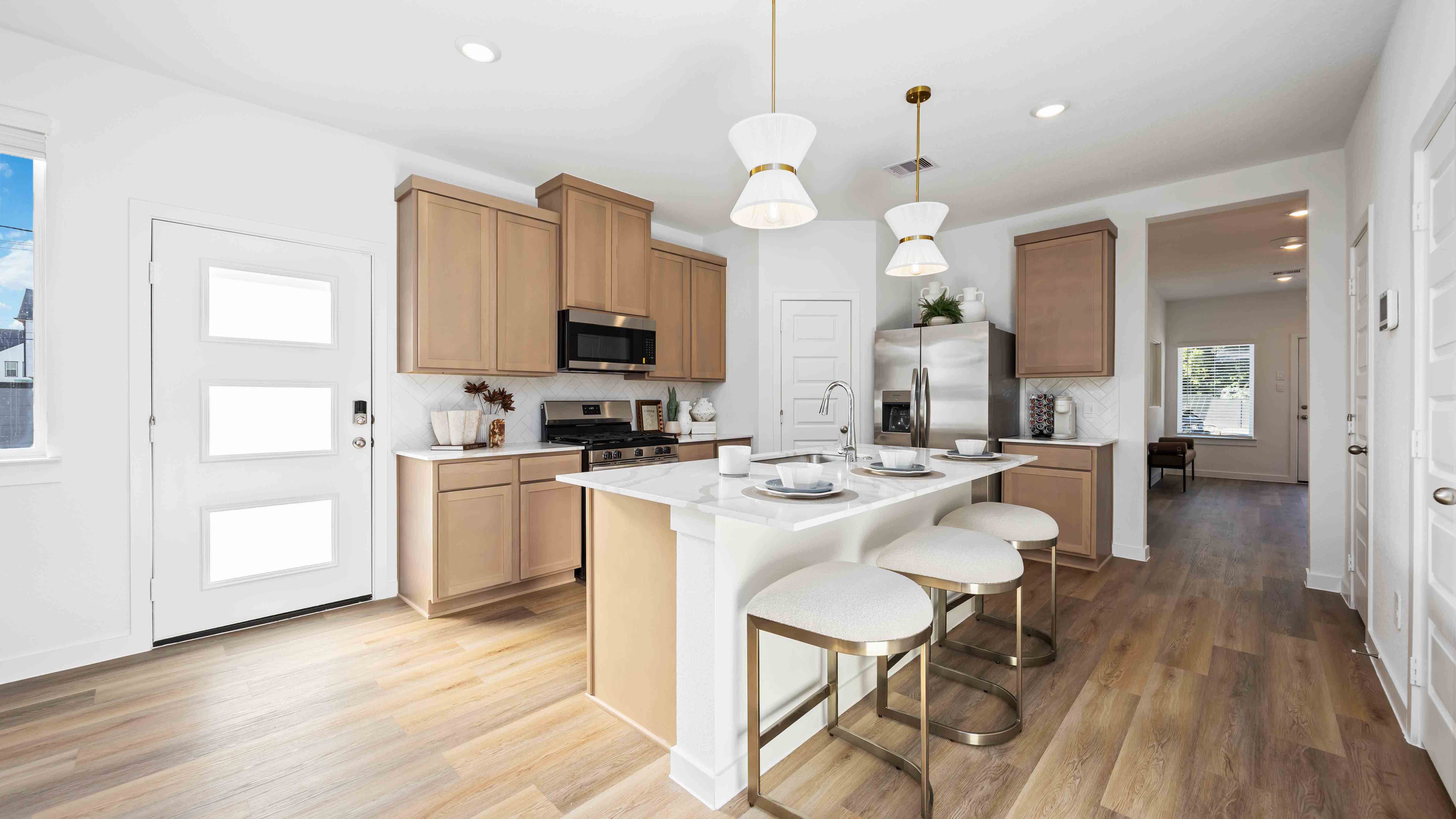 beautiful new kitchen with quartz counters, wood colored cabinets, and herringbone backsplash