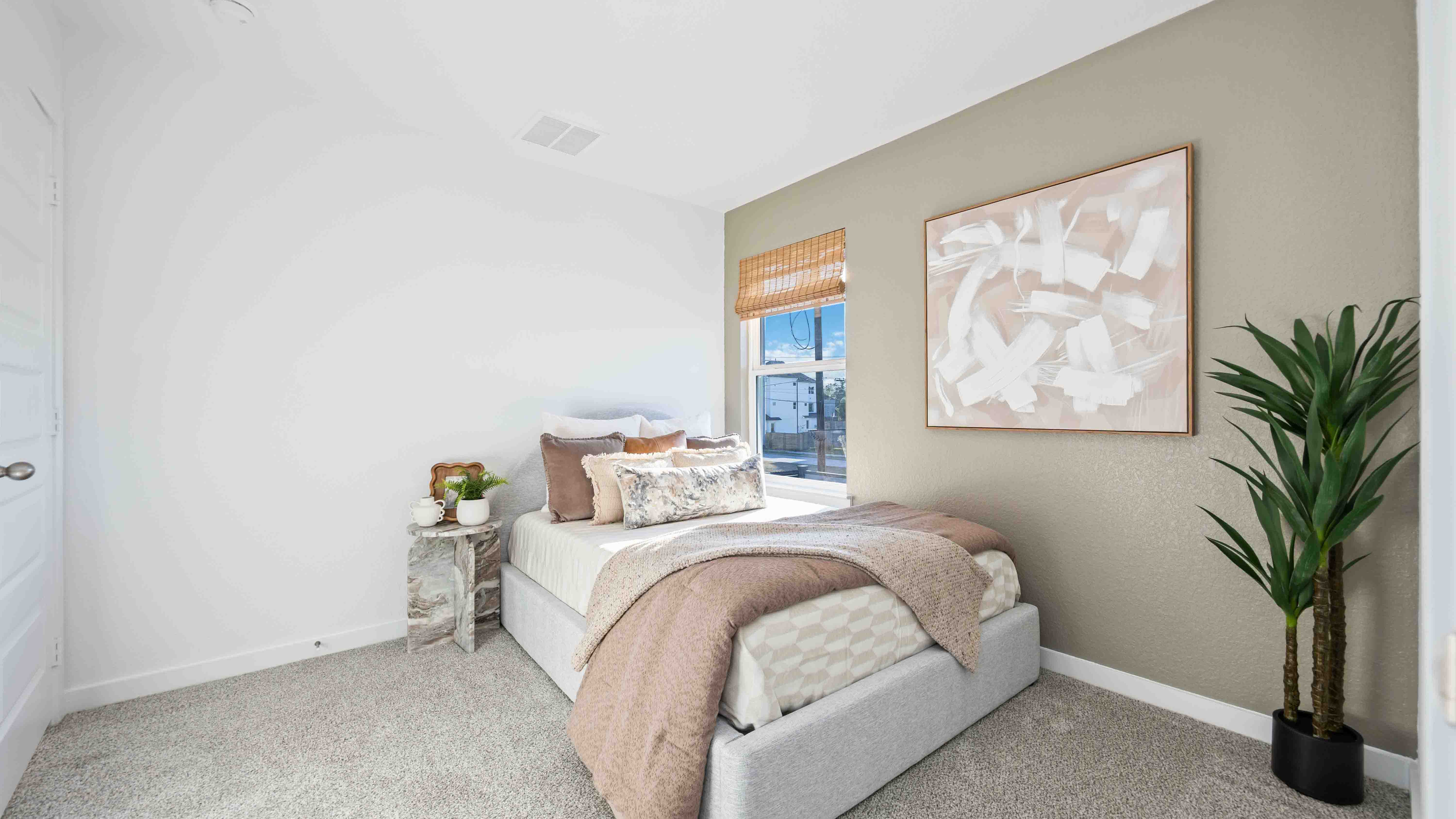 Comfortable guest bedroom featuring neutral-toned walls, carpeted flooring, and a separate closet.