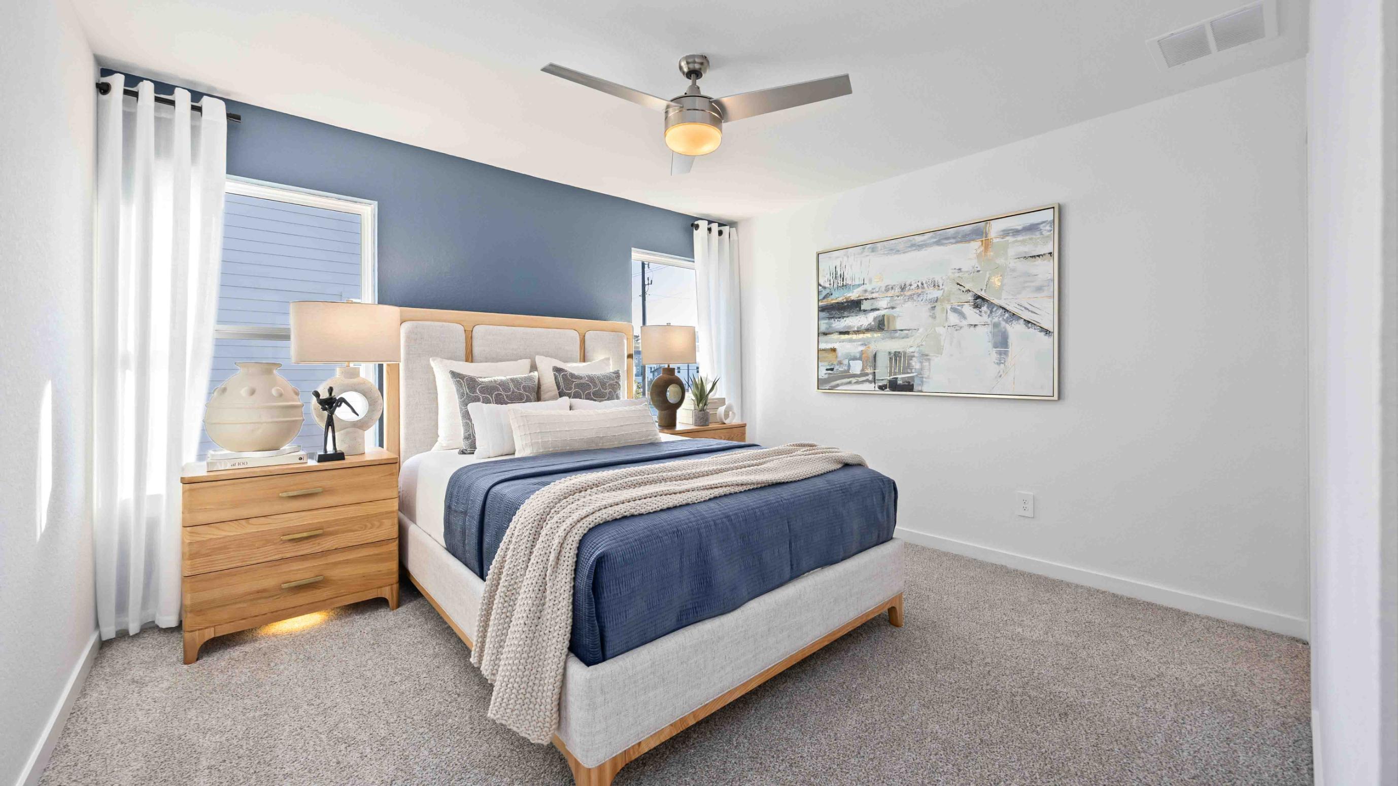 Primary bedroom with ceiling fan, plush carpeting, and a large walk-in closet.