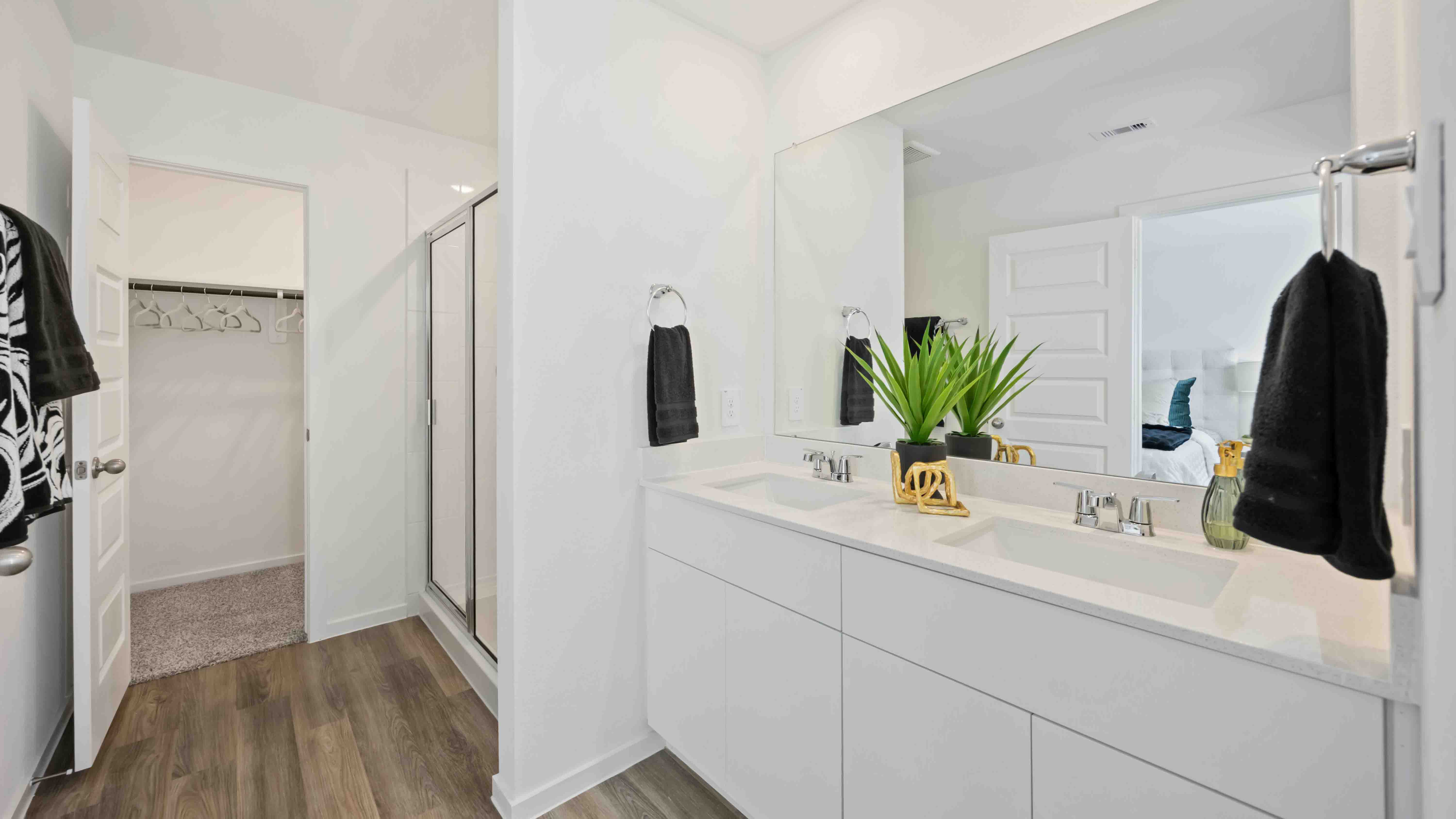 the en-suite primary bathroom has a double vanity and a standing shower