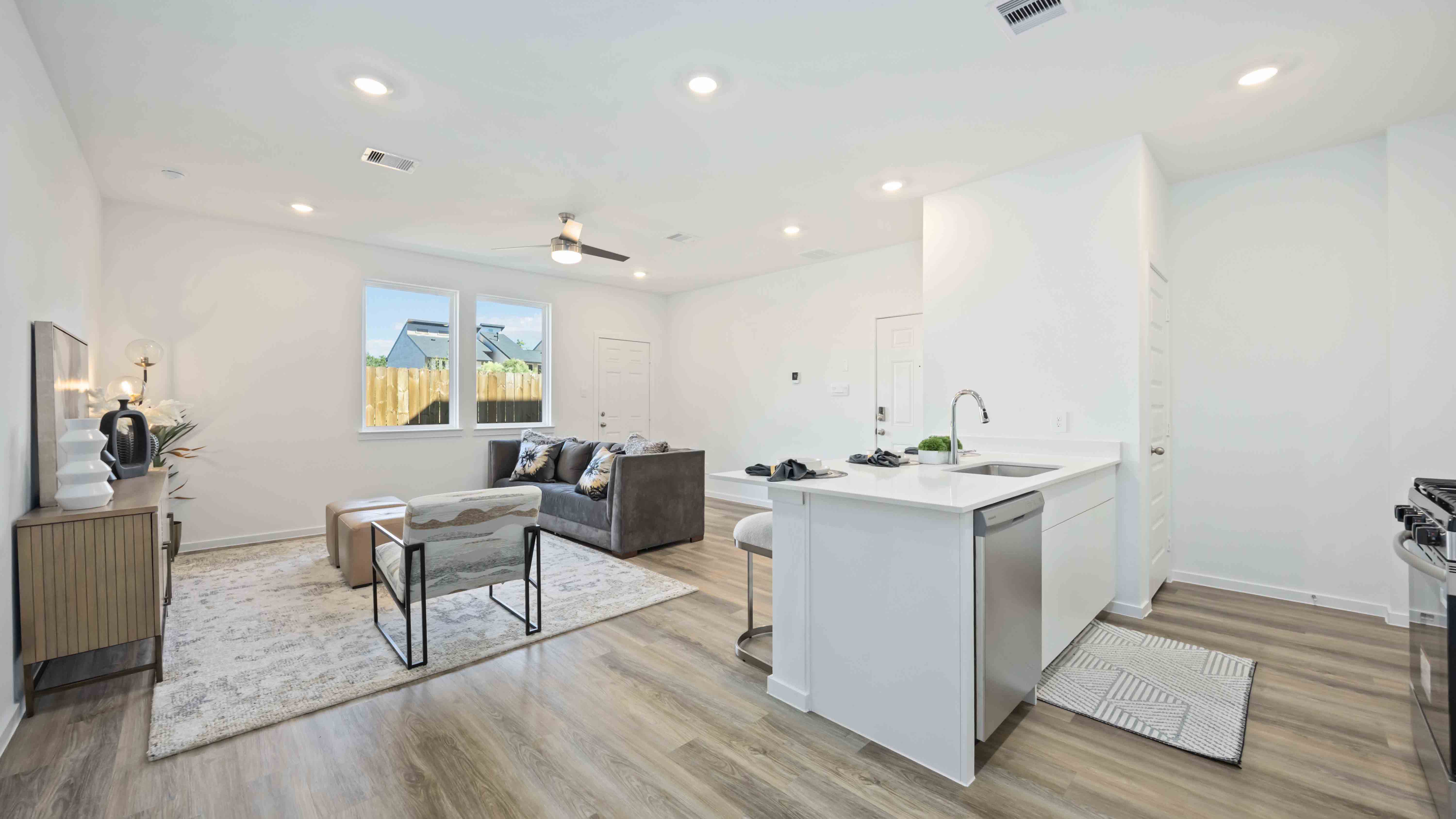 beautiful new kitchen with quartz counters, white cabinets, and stainless steel appliances