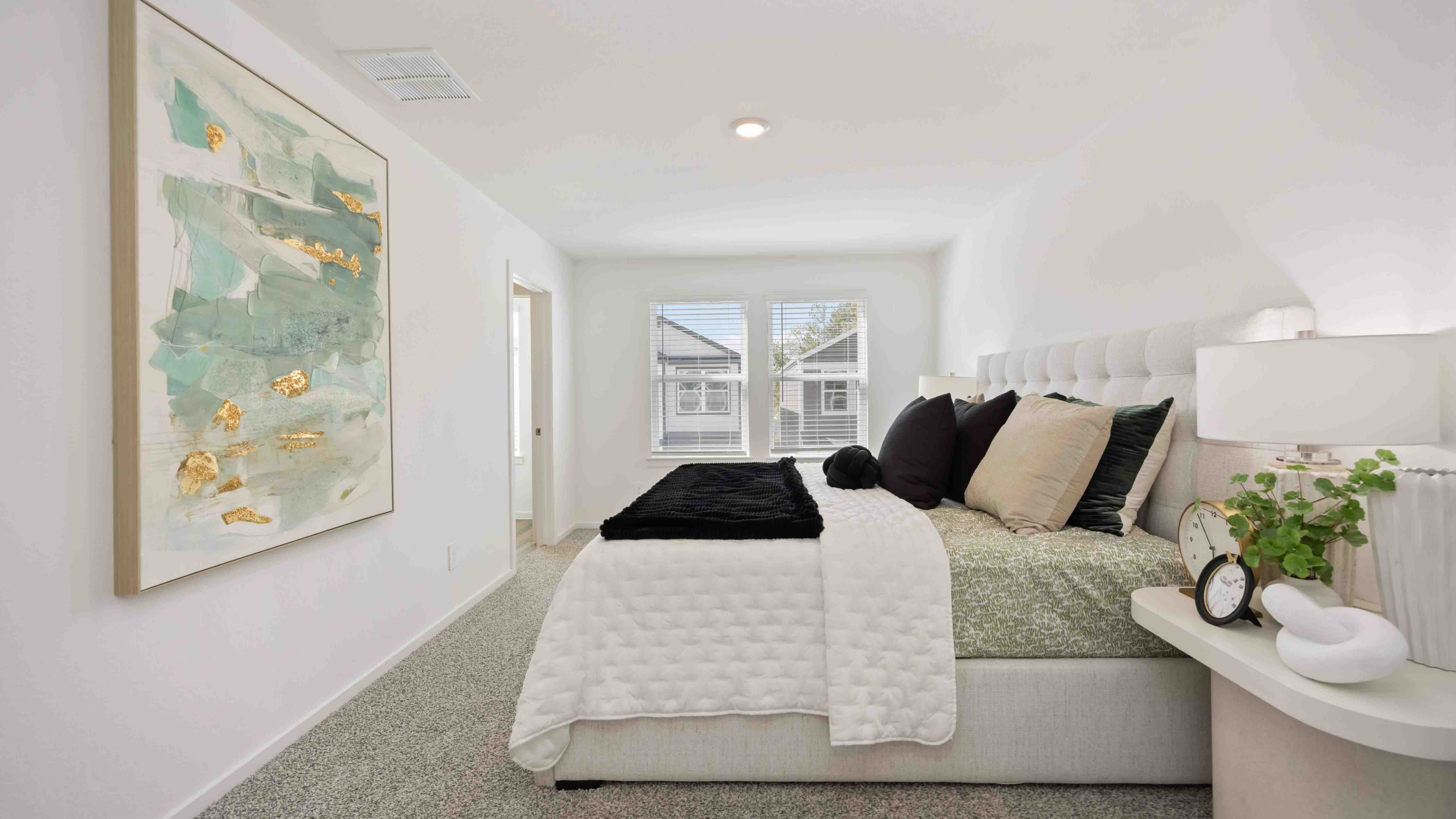a spacious primary suite comfortably fits a king size bed and additional bedroom furniture
