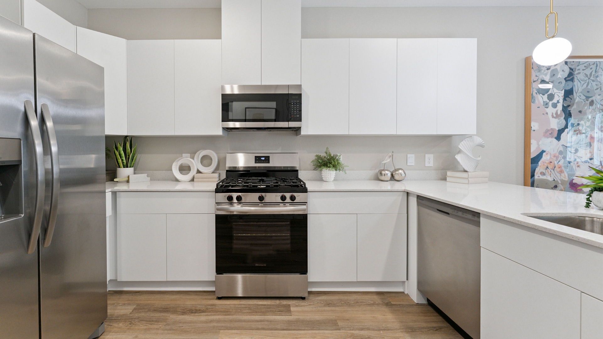 beautiful new kitchen with quartz counters, white cabinets, and stainless steel appliances