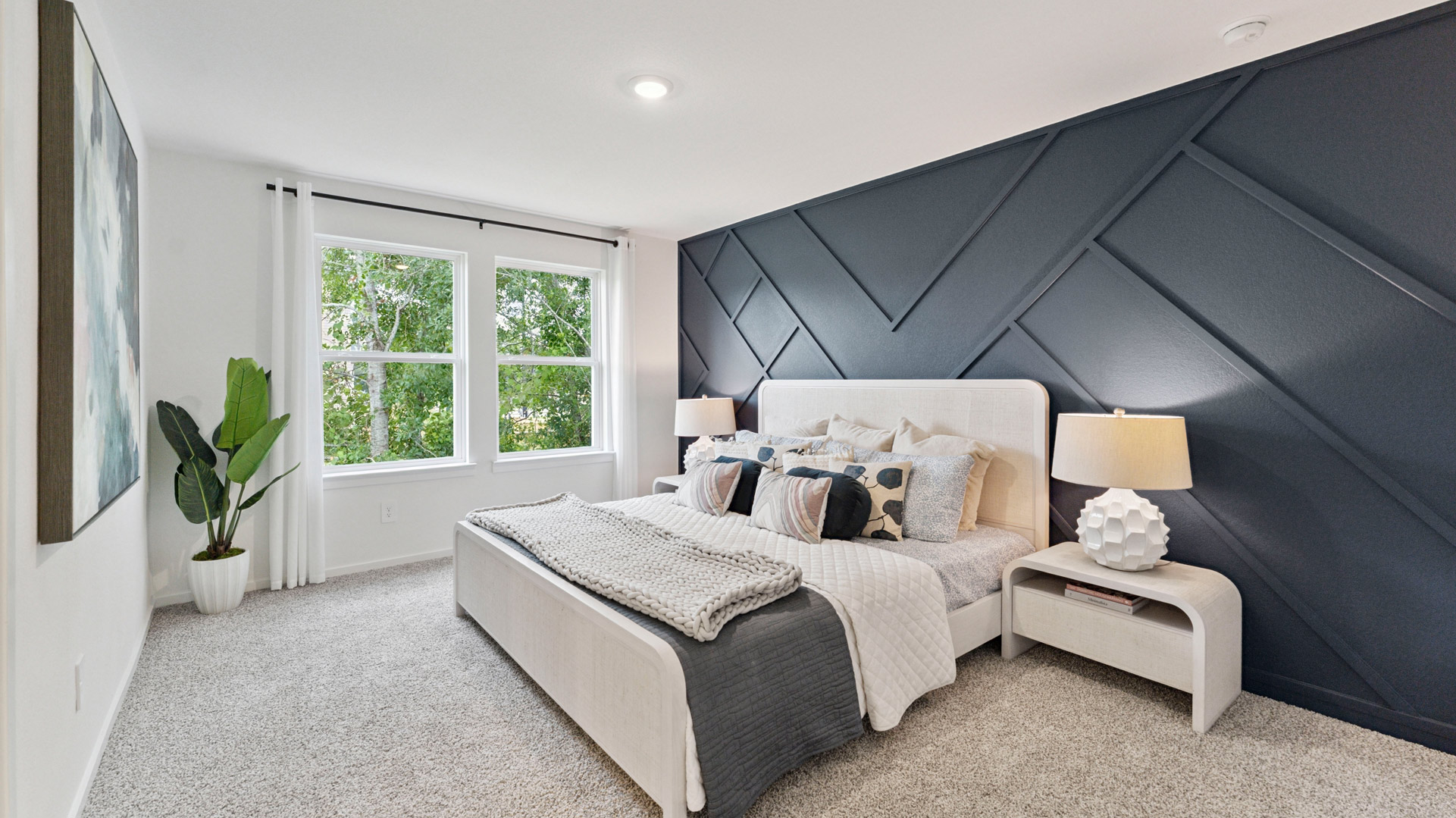 a spacious primary suite comfortably fits a king size bed and additional bedroom furniture