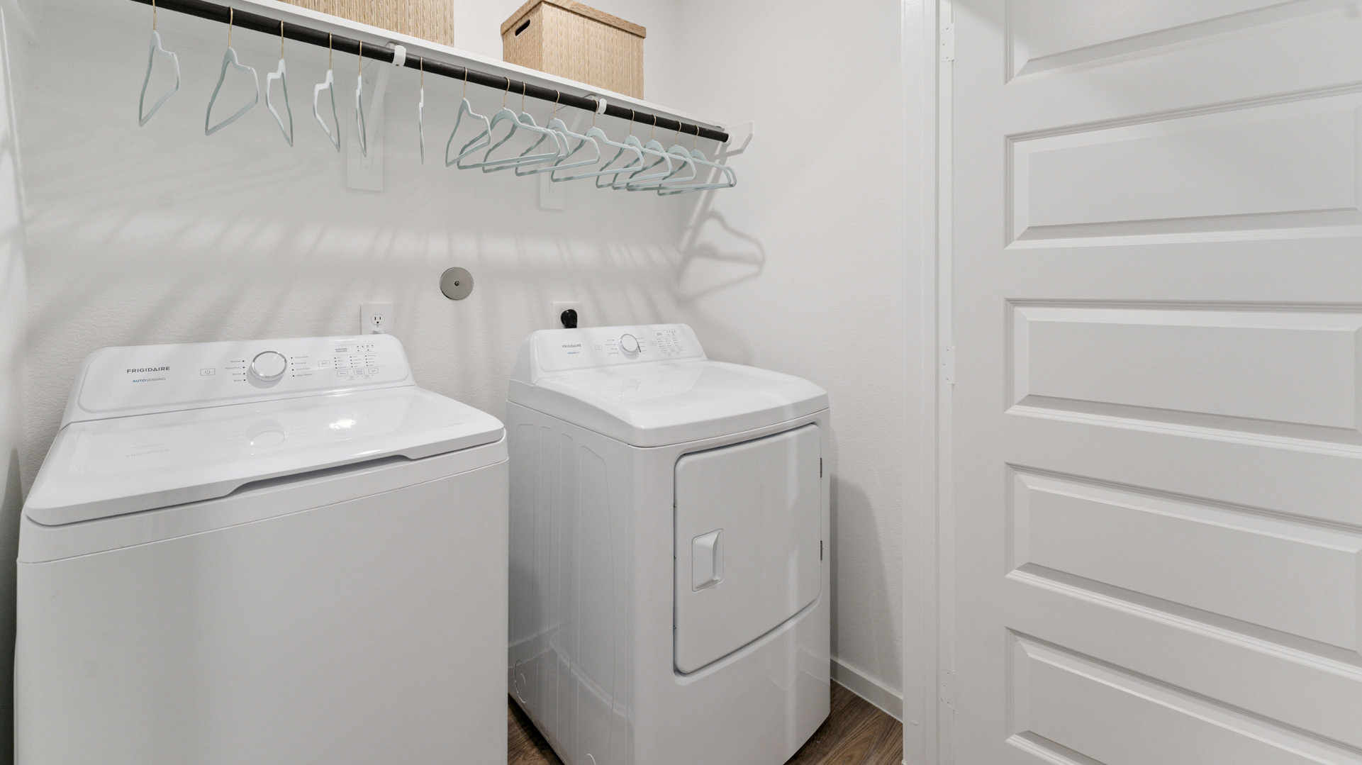 laundry room area with an open shelf and rod for additional storage and hanging clothes
