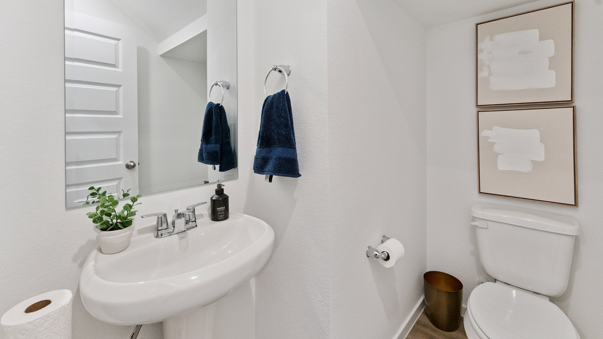 a downstairs powder bathroom with a pedestal sink