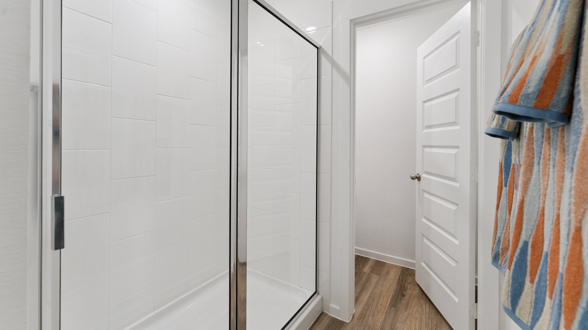 the primary shower has tile walls and a glass enclosure