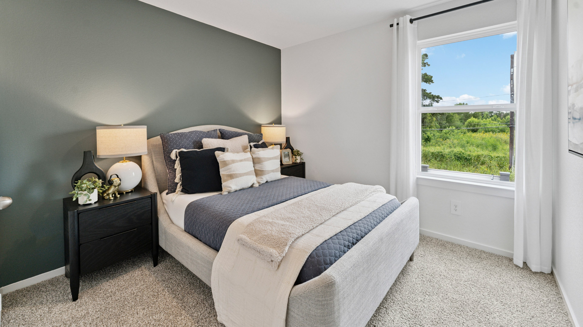 a second bedroom has a large window for natural light